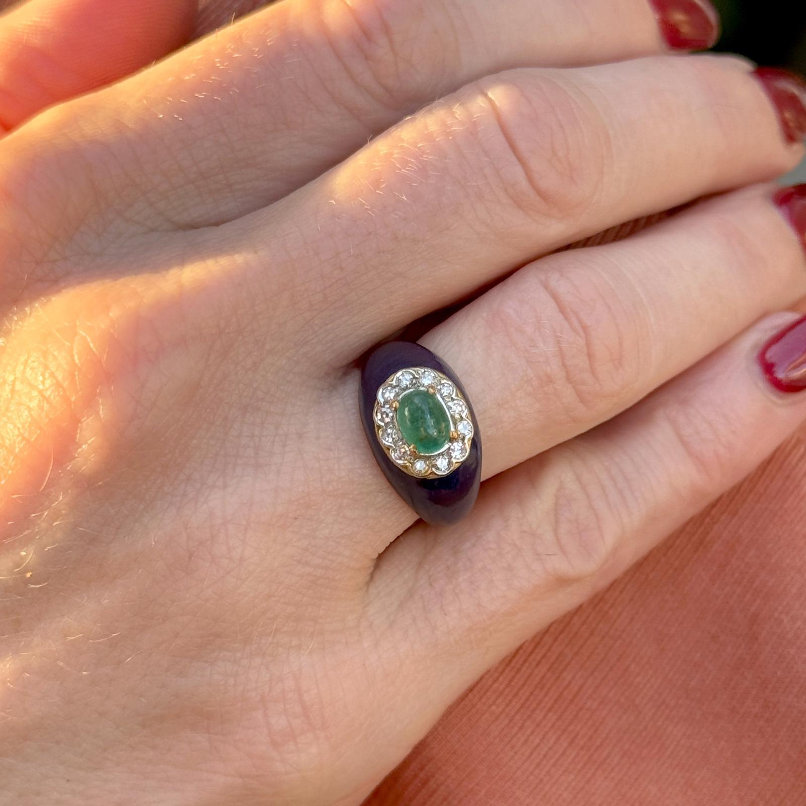 This vintage 18 karat yellow gold ring features an elegant oval cabochon green emerald at its center, radiating a rich, natural hue. Surrounding the emerald are 12 single-cut diamonds totaling 0.12 carats (H-I/SI), adding subtle sparkle. The ring is