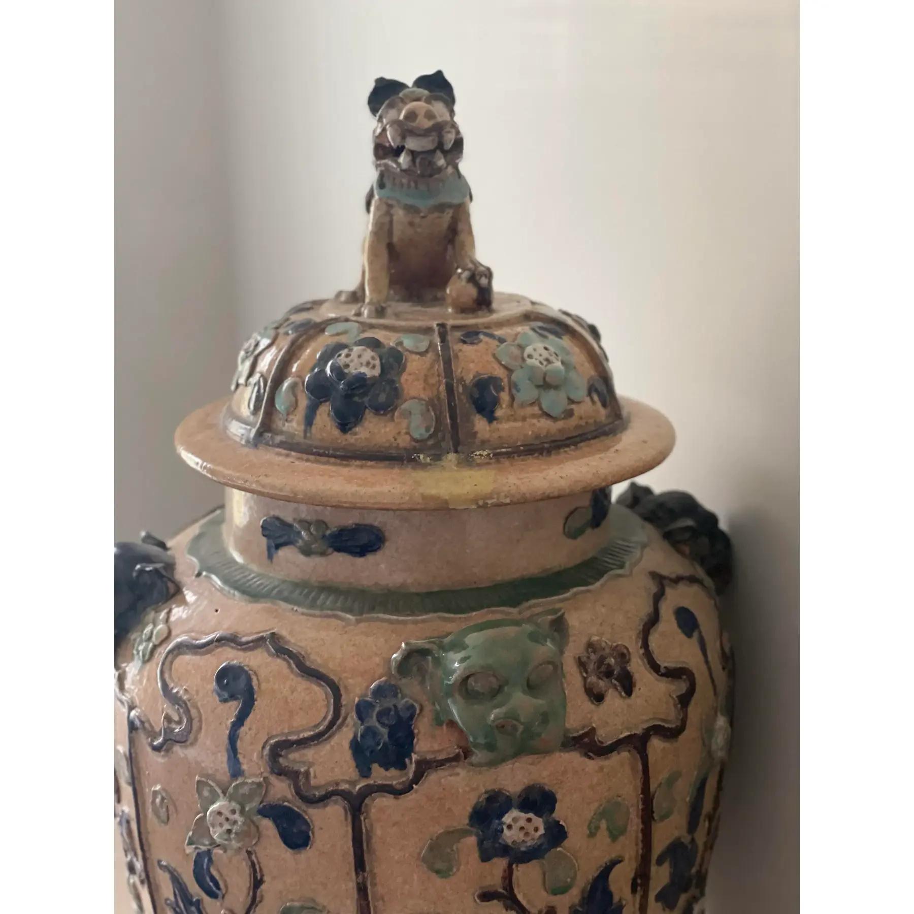 Questo impressionante barattolo di zenzero da terra della metà del XX secolo presenta una forma imponente in stile imperatore e un terminale a forma di cane da caccia intricatamente scolpito. Alto ben 33 pollici, il vaso presenta una classica