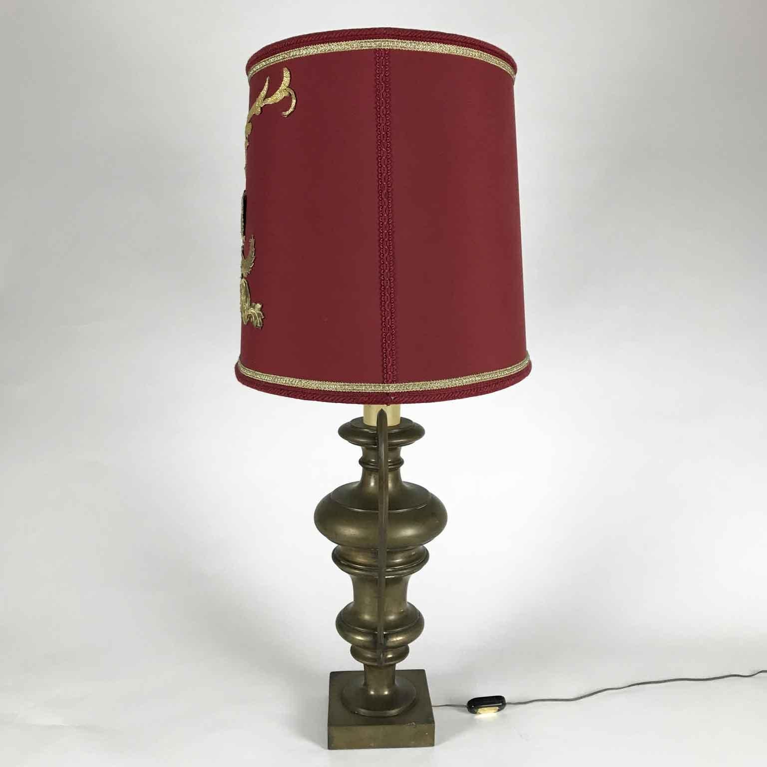 An Empire style large bronze urn vase wired as table lamp with an oval red lampshade. An Italian circular handled decorative bronze center vase, the so-called Italian portapalme, set on square base, realized in cast bronze, this exquisite mid-20th