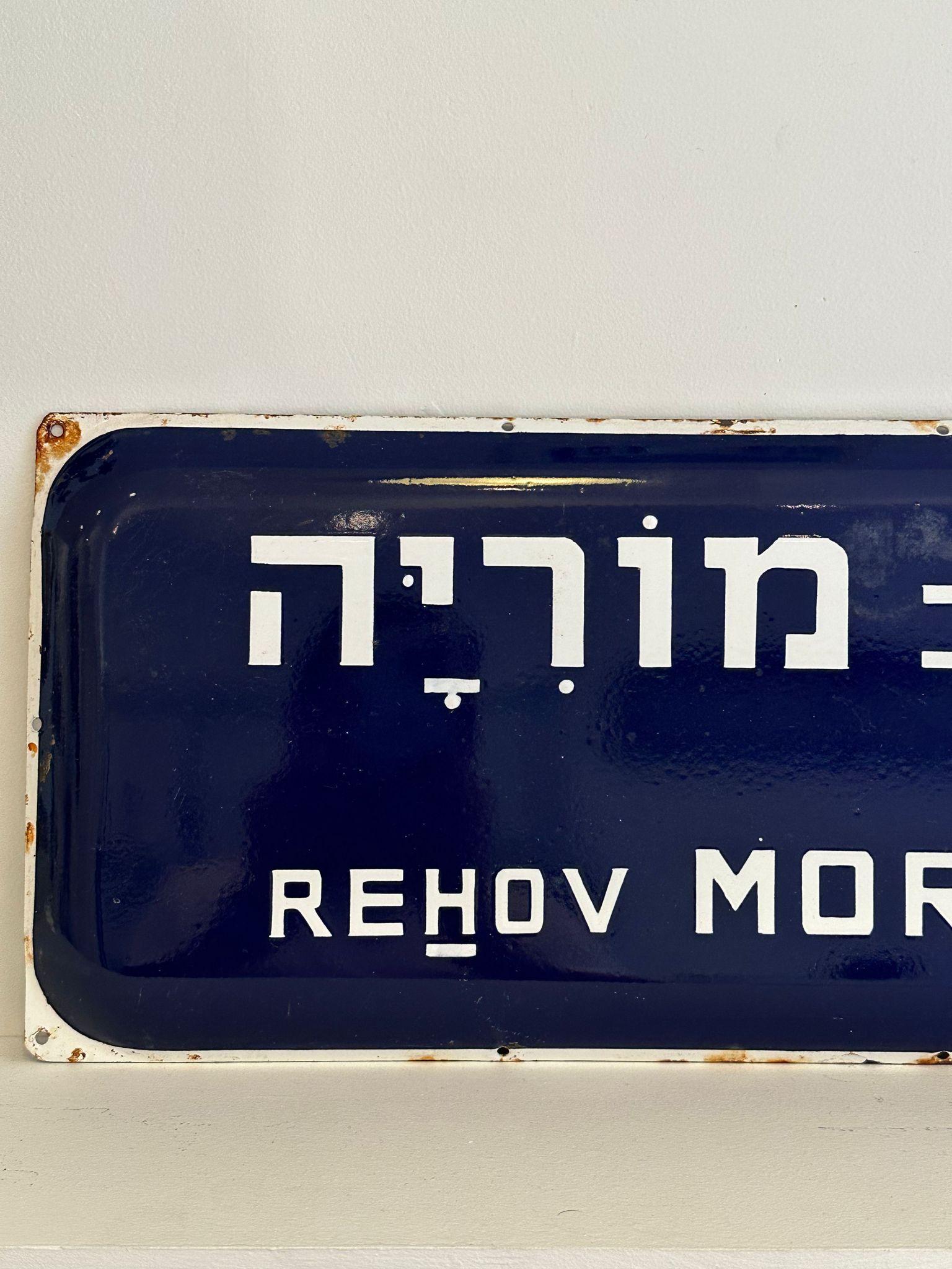 Mid-20th century handmade Israeli street name sign. Made of enamel and iron, this street sign was created shortly after the establishment of the state of Israel in 1948. The sign is written in bolt white letters over a dark blue background, alluding