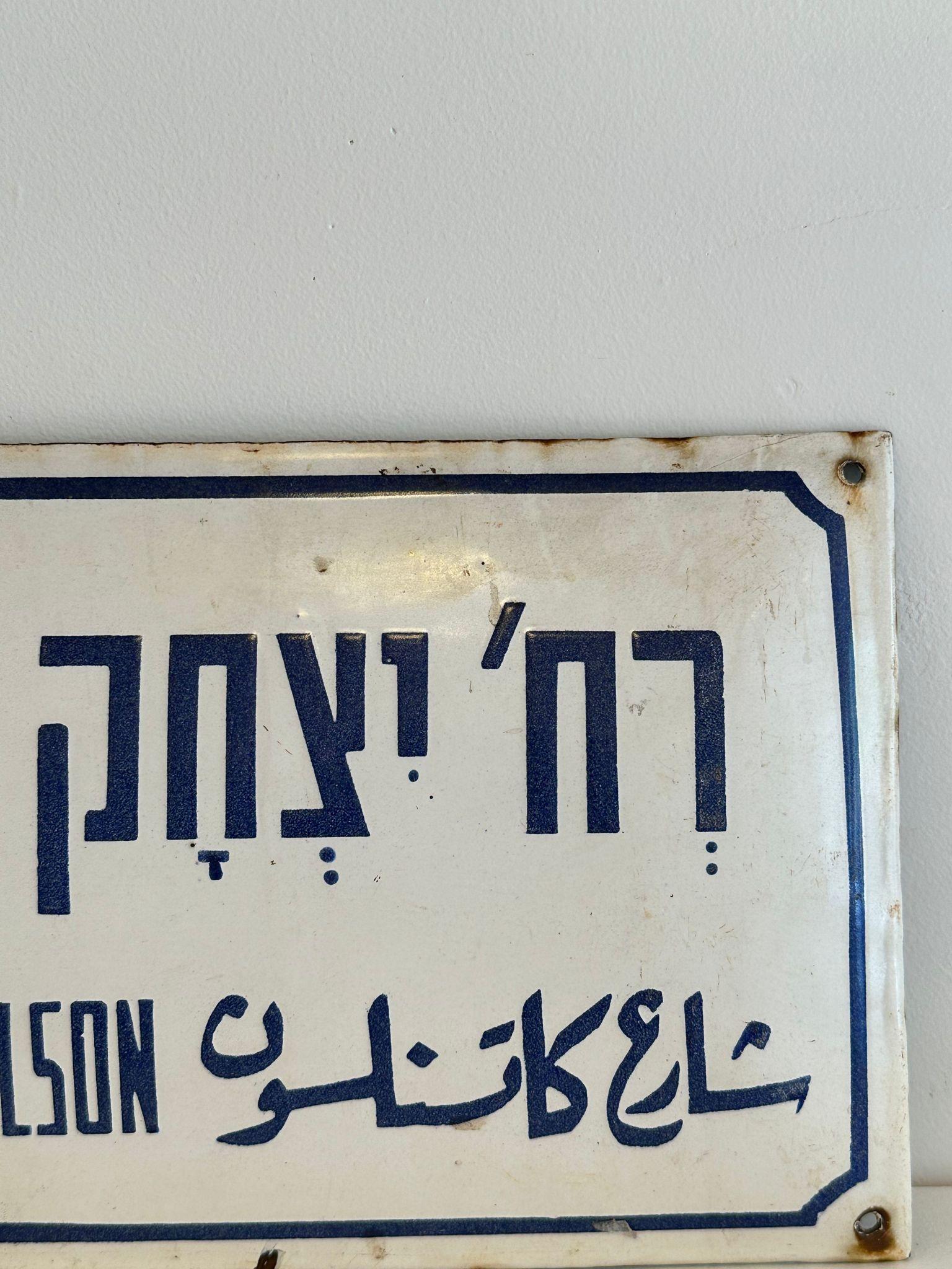 Mid-20th century handmade Israeli street name sign. Made of enamel and iron, this street sign was created shortly after the establishment of the state of Israel in 1948. The sign is written in bolt blue letters over a white background, alluding to