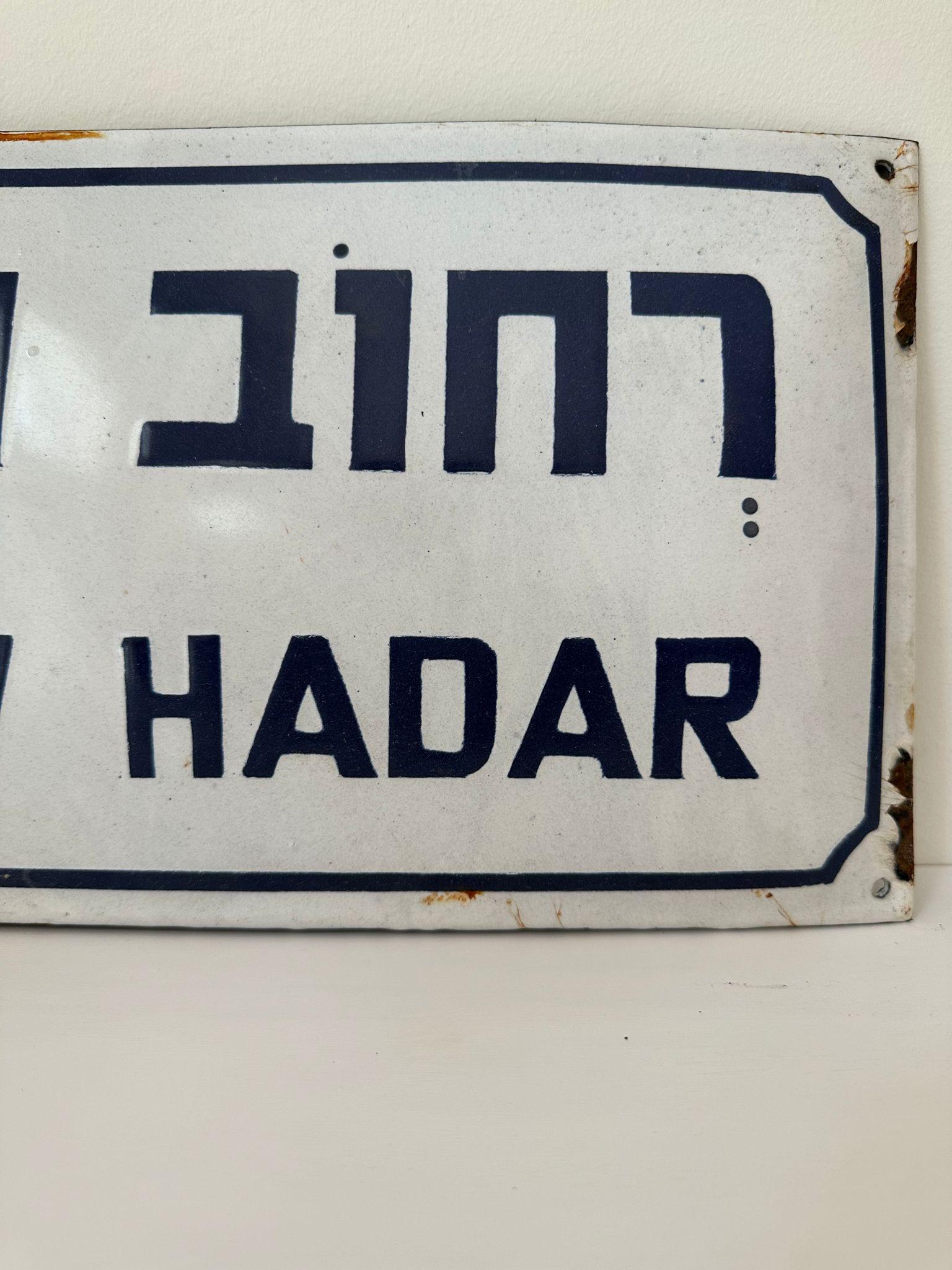 Mid-20th century handmade Israeli street name sign. Made of enamel and iron, this street sign was created shortly after the establishment of the state of Israel in 1948. The sign is written in bolt blue letters over a white background, alluding to