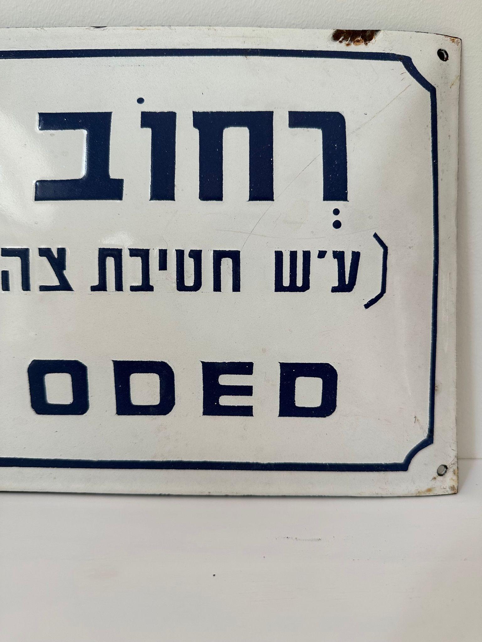 Mid-20th century handmade Israeli street name sign. Made of enamel and iron, this street sign was created shortly after the establishment of the state of Israel in 1948. The sign is written in bolt blue letters over a white background, alluding to