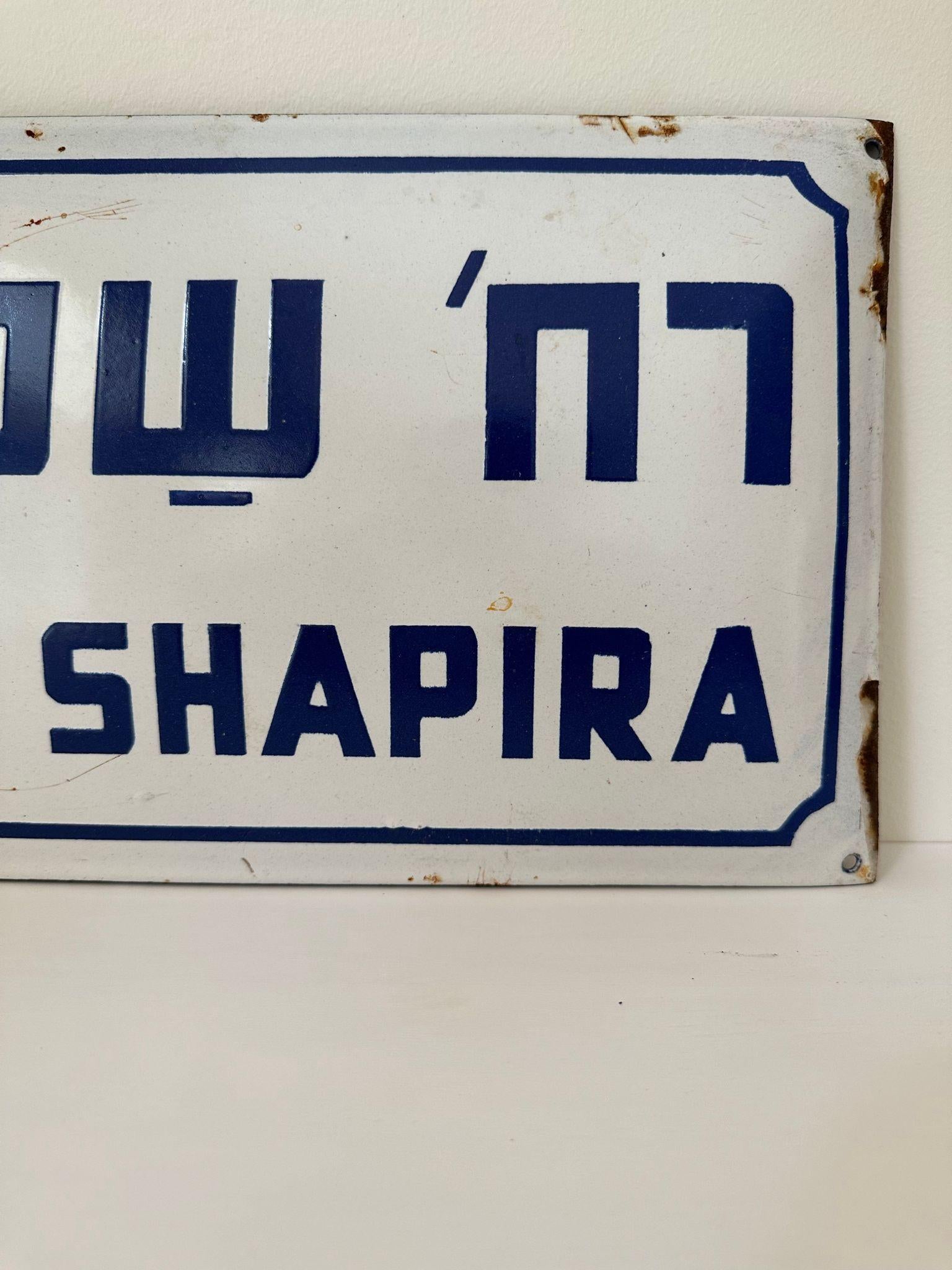 Mid-20th century handmade Israeli street name sign. Made of enamel and iron, this street sign was created shortly after the establishment of the state of Israel in 1948. The sign is written in bolt blue letters over a white background, alluding to
