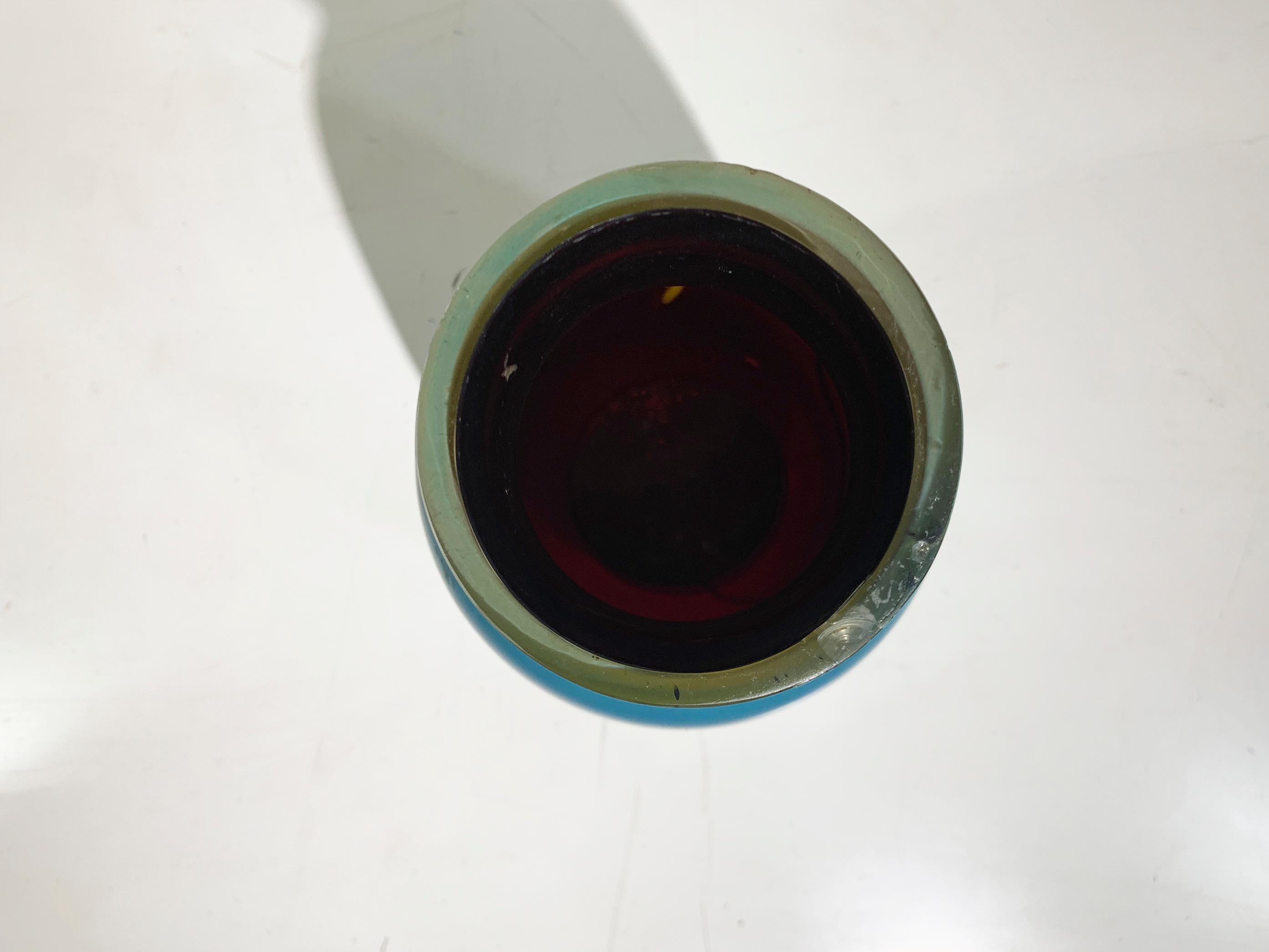 Questo vaso in vetro smaltato dal design elegante, originario della Francia degli anni '50, mostra una semplicità e una maestria senza tempo. Il vaso è caratterizzato da una silhouette liscia e minimalista con un corpo dolcemente affusolato che si