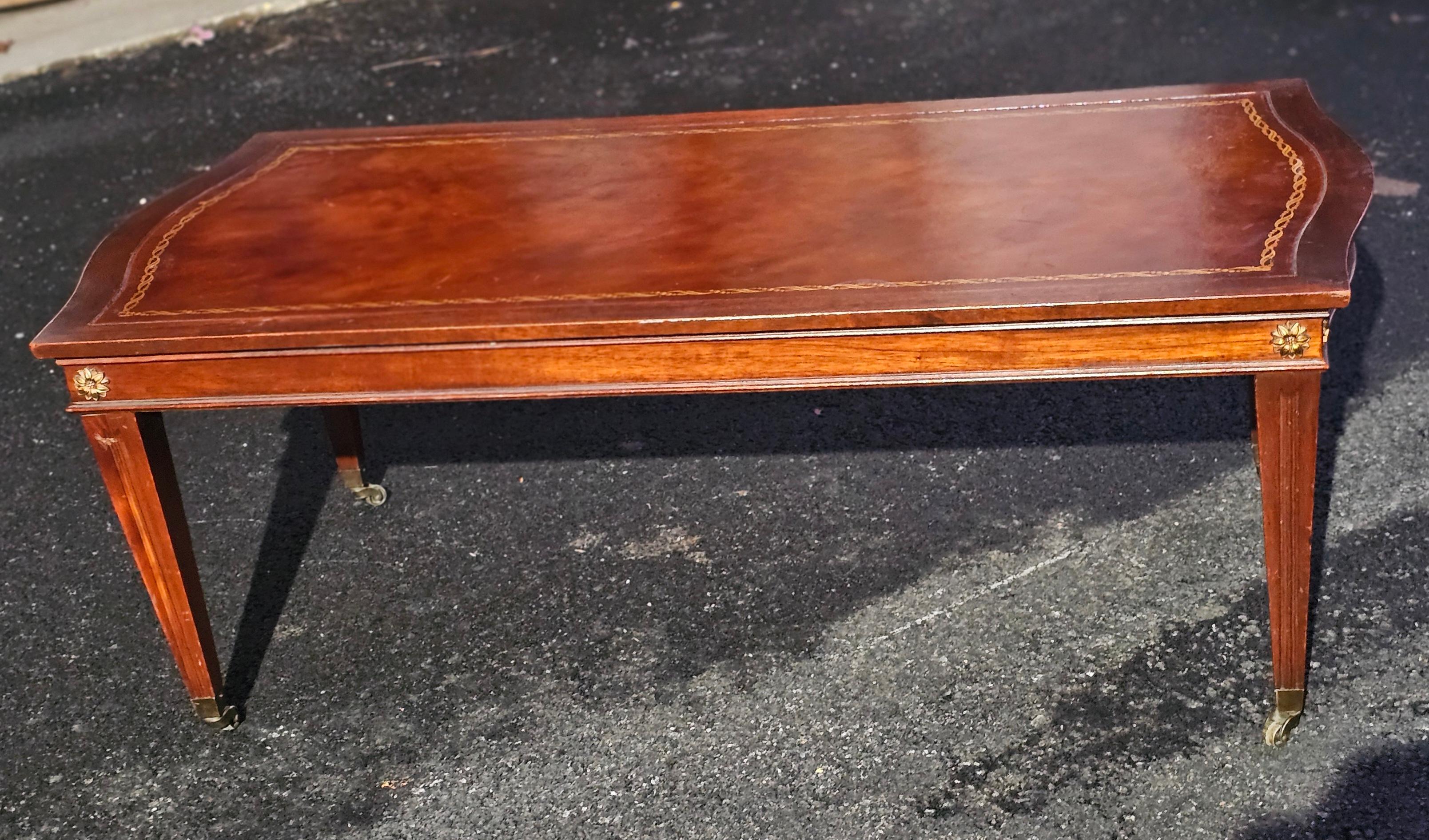 Table à café / table à cocktail à roulettes en acajou de style Régence anglaise du milieu du 20e siècle, avec dessus en cuir peint au pochoir.
Mesure 45,5
