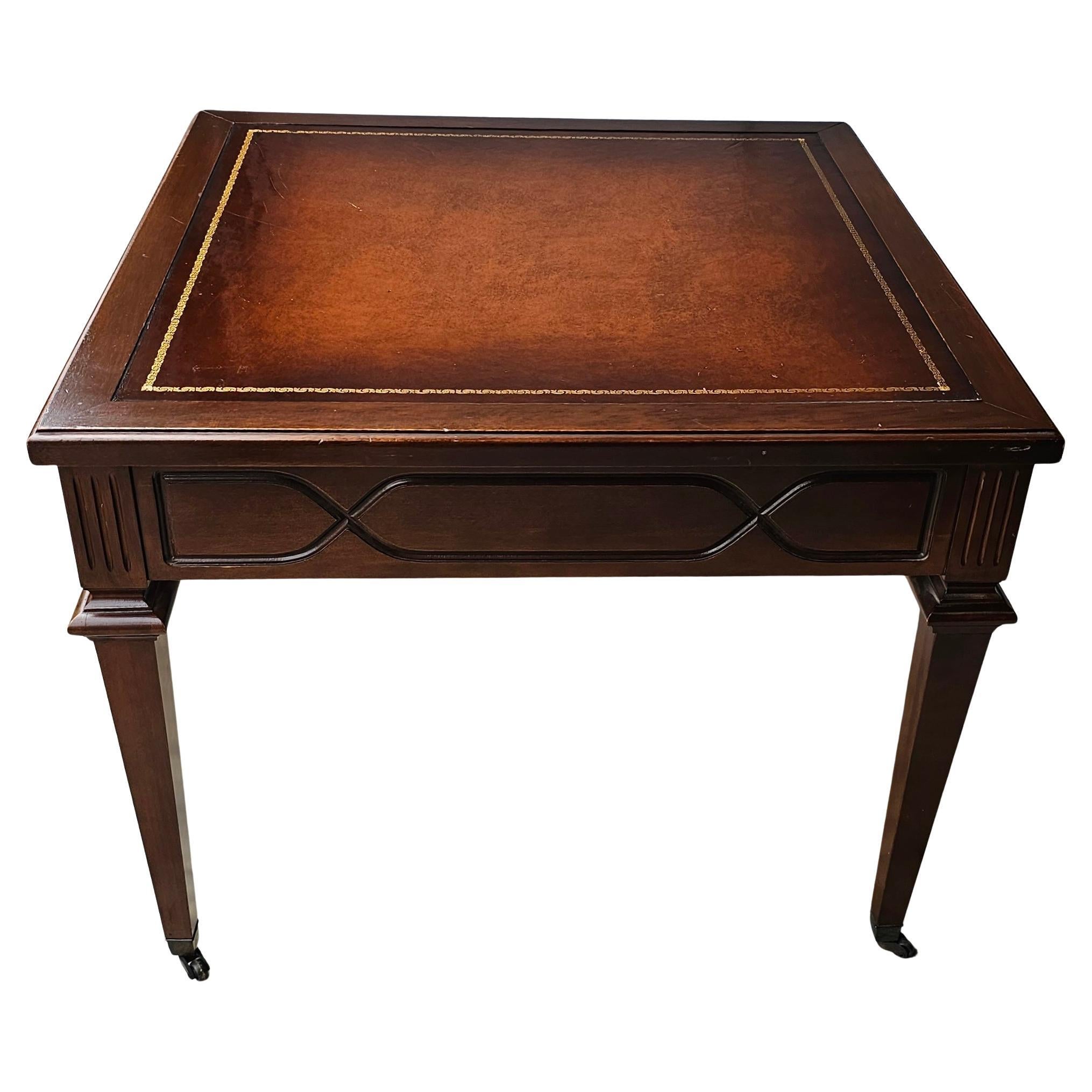 A Mid-20th Century English Regency Mahogany and Tooled Leather Stenciled Side Table on wheels.
 Its dimensions are approximately 26 inches wide x 26 inches in depth and 20.75