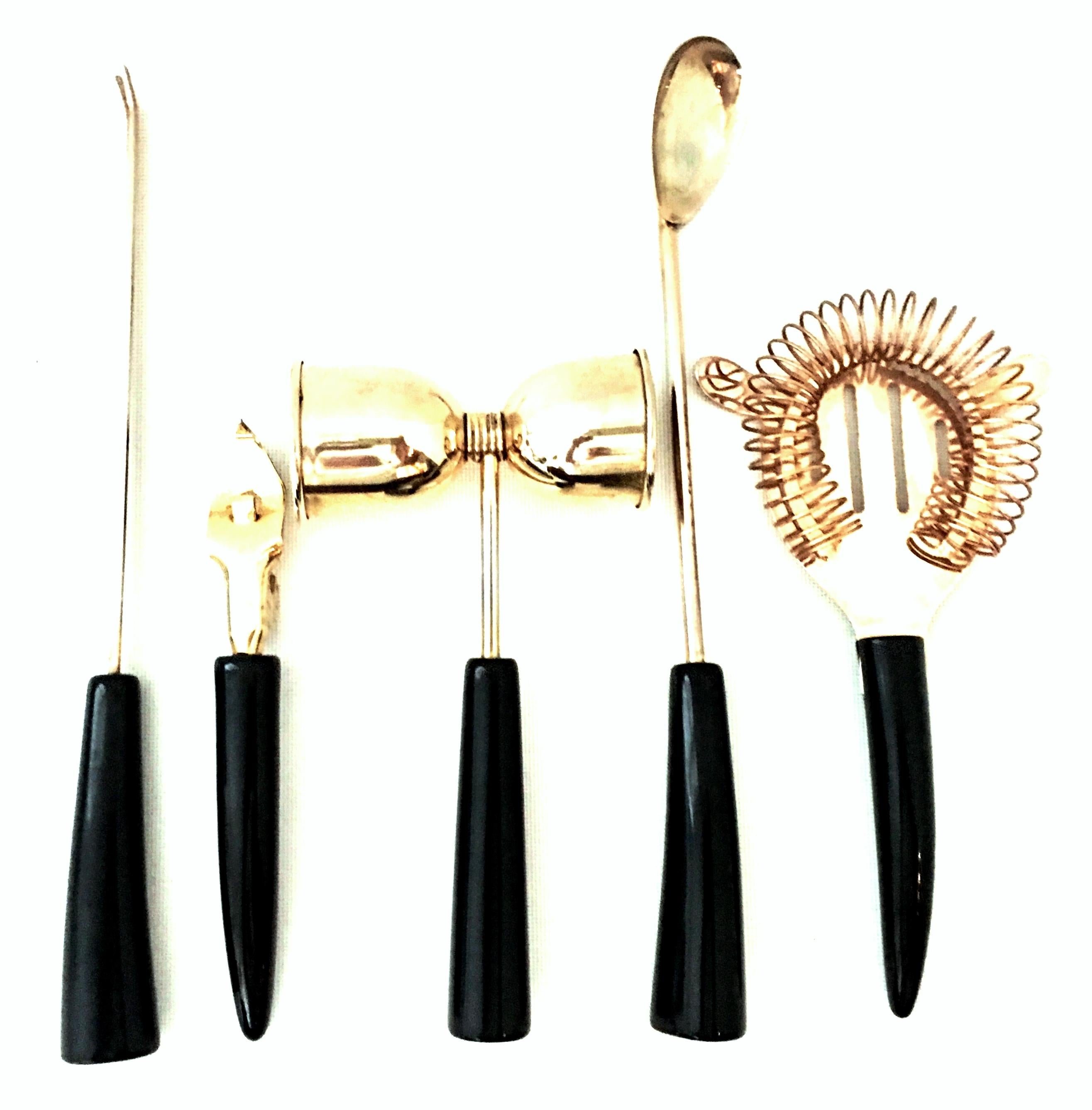 Mid-20th century English 24-karat, gold plate and black Lucite handled bar tools set of 5 pieces by, Regent Sheffield. This five-piece set includes, 1 Hawthorne strainer, 1 bar spoon, 1 bar fork, 1 bottle opener and 1 double bell shaped handled