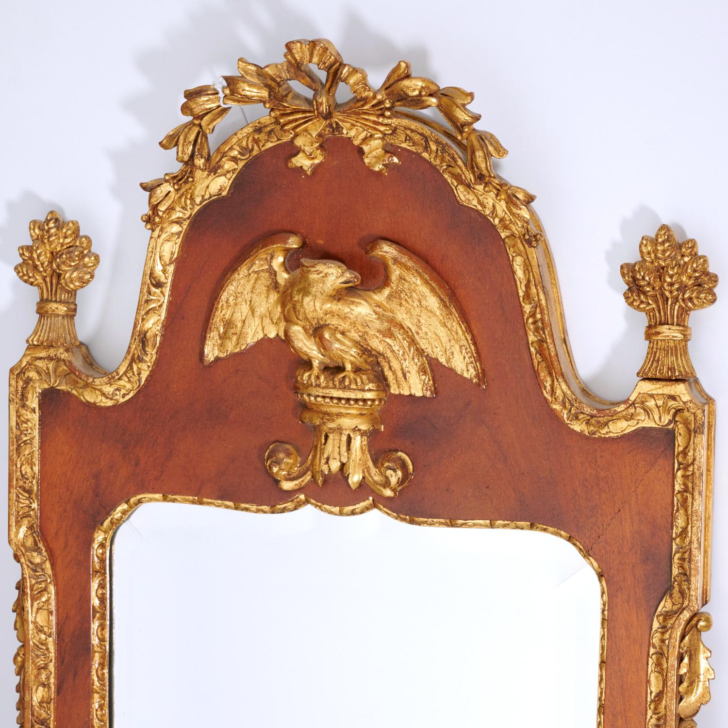 20th c., Decorative Federal-style mirror in mahogany with eagle in relief, ribbon and bellflower crest, wheat sheaf finials, acorn side detail, beveled glass, unmarked.

An elegant and timeless way to add visual interest to your home. With its
