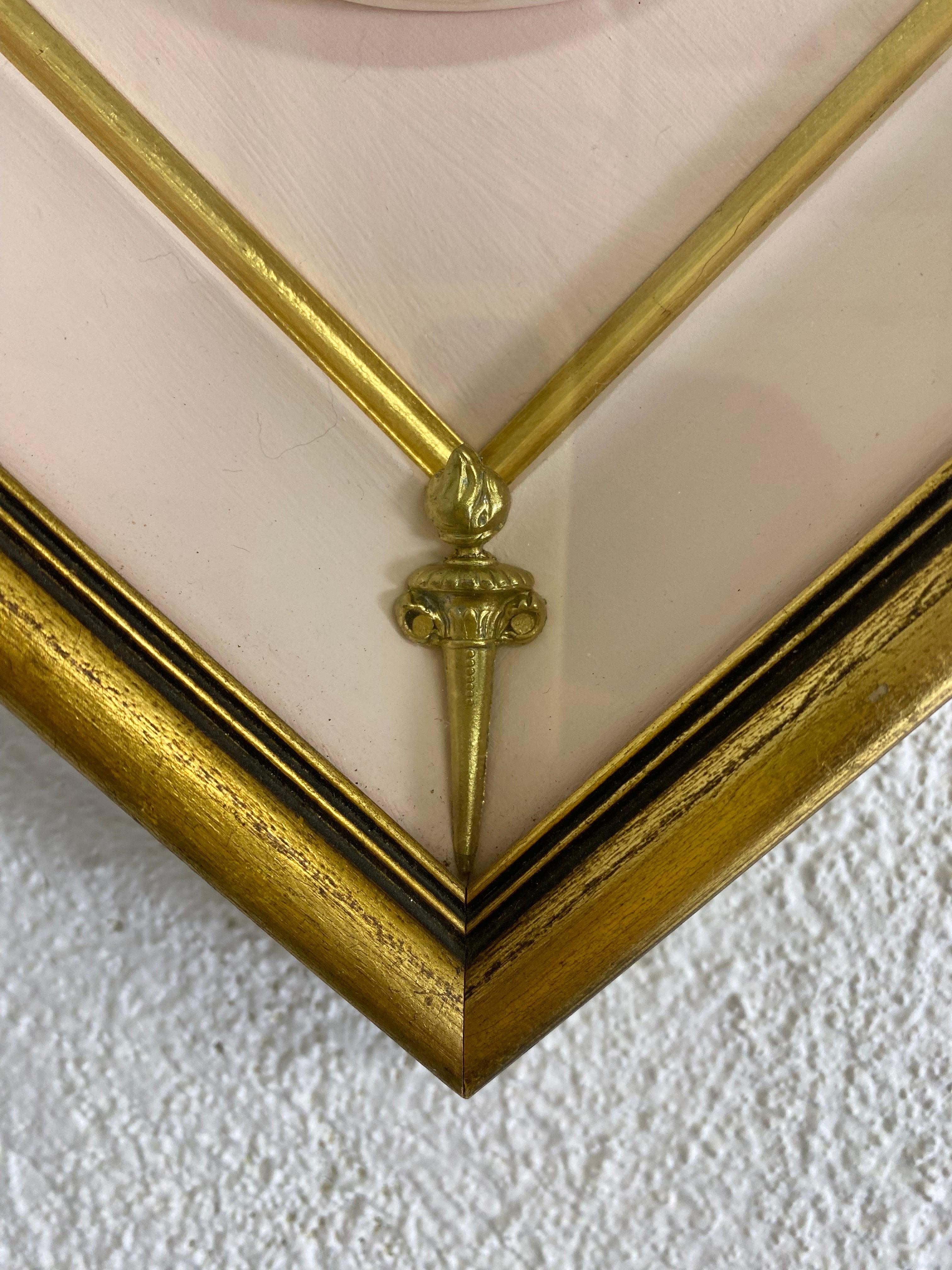 Il s'agit d'un Taglio italien en biscuit à cadre datant du milieu du 20e siècle. Ce médaillon en porcelaine biscuit de style gréco-romain est encadré dans un cadre à feuilles d'or avec un intérieur rose et des détails dorés. Ce cadre médaillon a été
