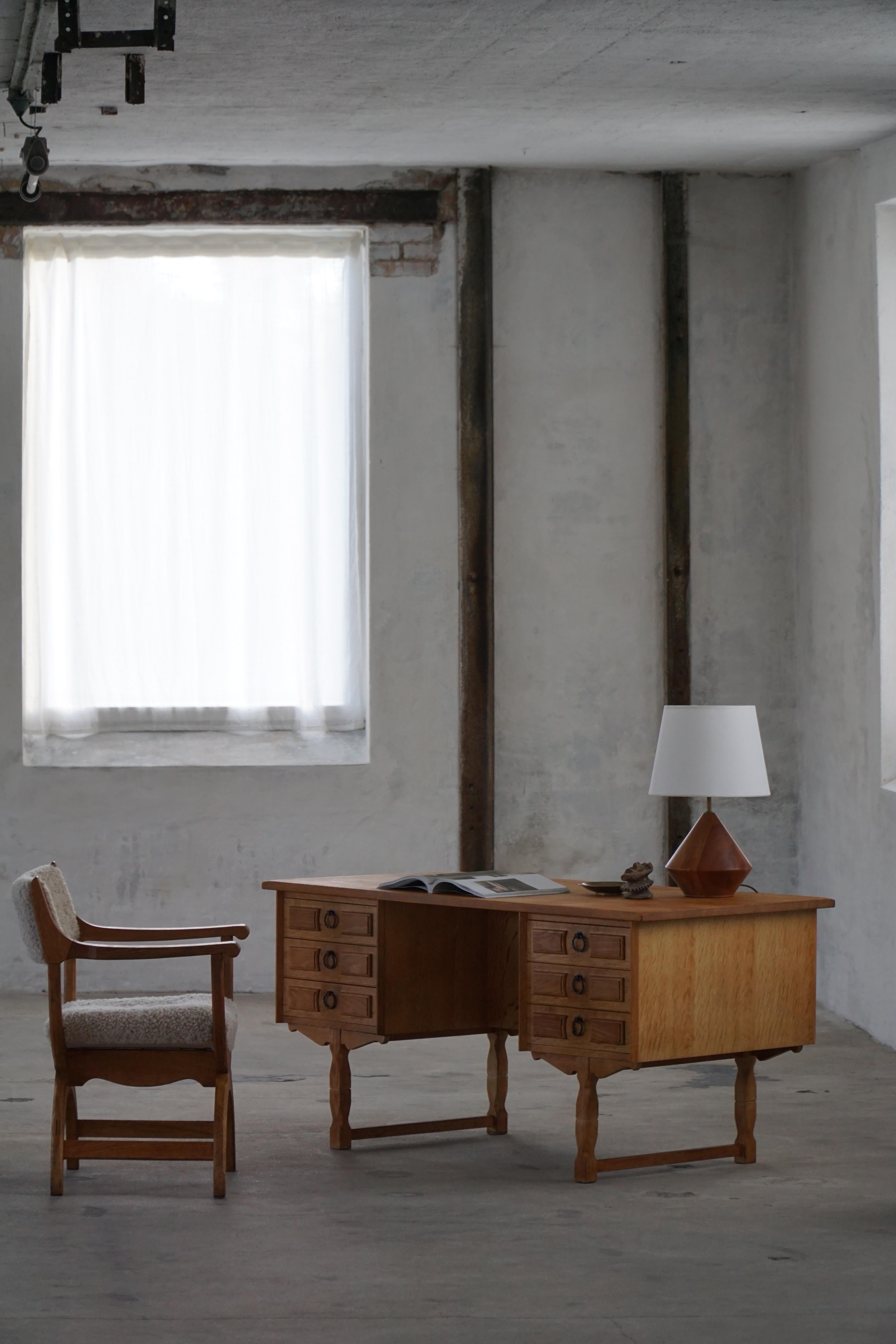 A sculptural freestanding oak executive desk by Henning Kjærnulf, crafted in Denmark circa 1960s. The design showcases the expressive wood craftsmanship and sculpted contours characteristic of Danish modern furniture from this era.

The desk