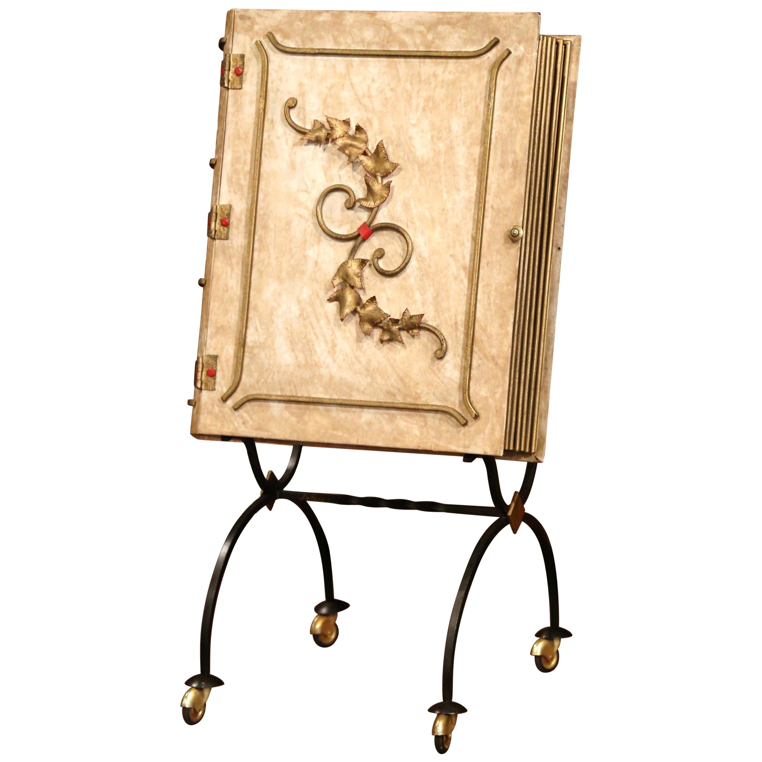 This large vintage leather book on wheels’ bar cart was found in Lyon, France. Crafted circa 1950, the large front cover opens to reveal an inside bar with a shelf for glasses and four bottles holder compartments. The front is embellished by painted