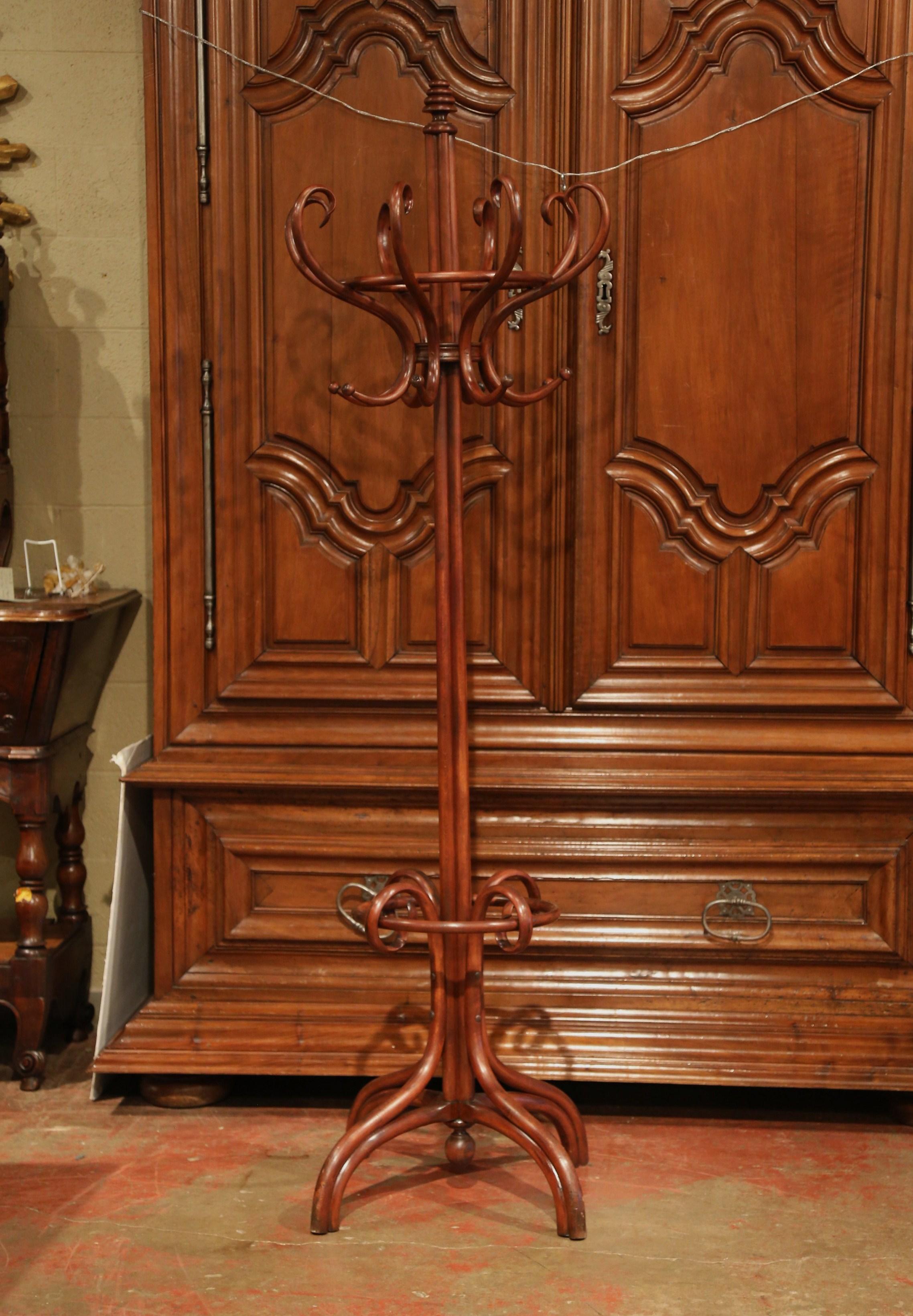 Bring a retro, yet practical touch to any entry or dressing area with this elegant, carved coat and hat stand. The wooden stand was crafted in Paris, France, circa 1950, after the German-Austrian cabinet maker, Michael Thonet (1796-1871). The