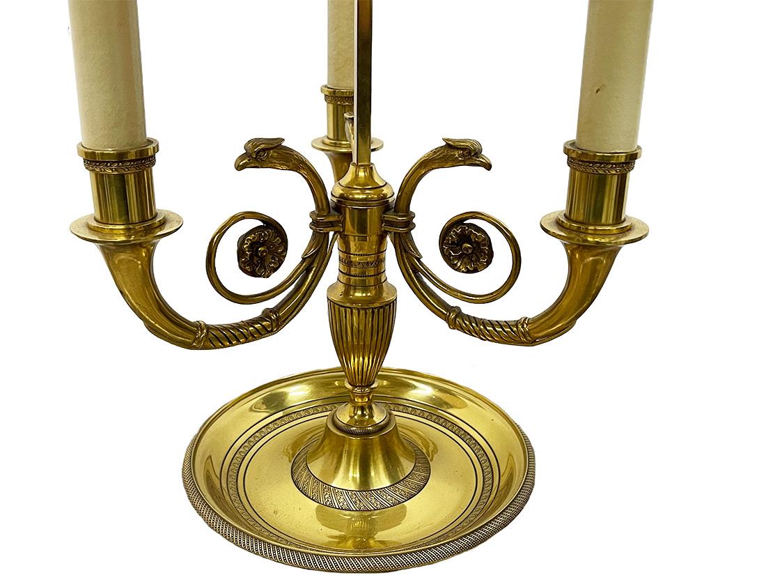 Mid 20th Century French brass Bouillotte lamp

A French mid 20th Century Bouillotte lamp in brass with an Eagle scrolled three armed base and  a metal green adjustable shade
The measurement is 80 cm high and the shade is 42 cm diagonal
The total