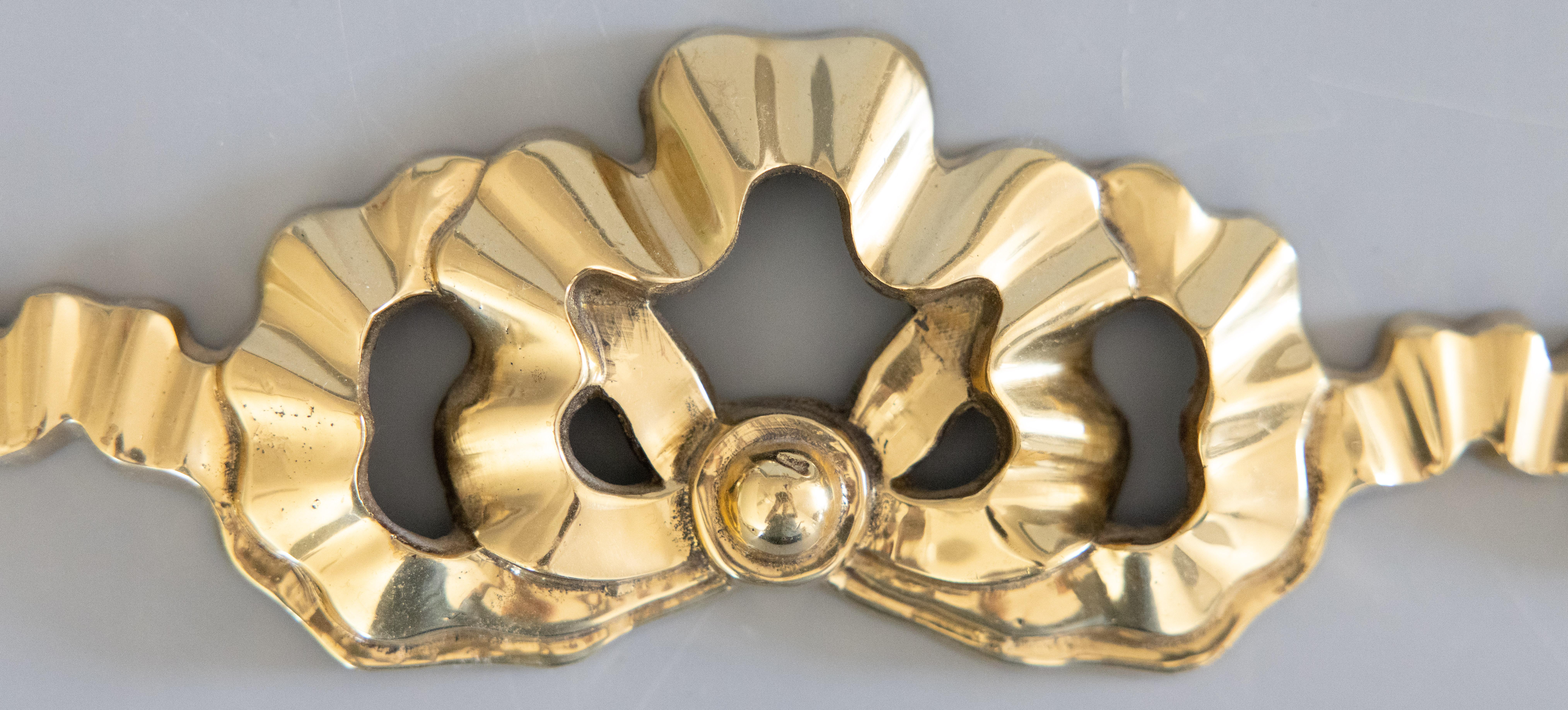 A beautiful vintage French brass bow and ribbon wall ornament swag garland. This charming wall swag has a beautiful brass patina and is the perfect accent piece for any wall.

DIMENSIONS
12.5ʺW × 0.5ʺD × 3.25ʺH
