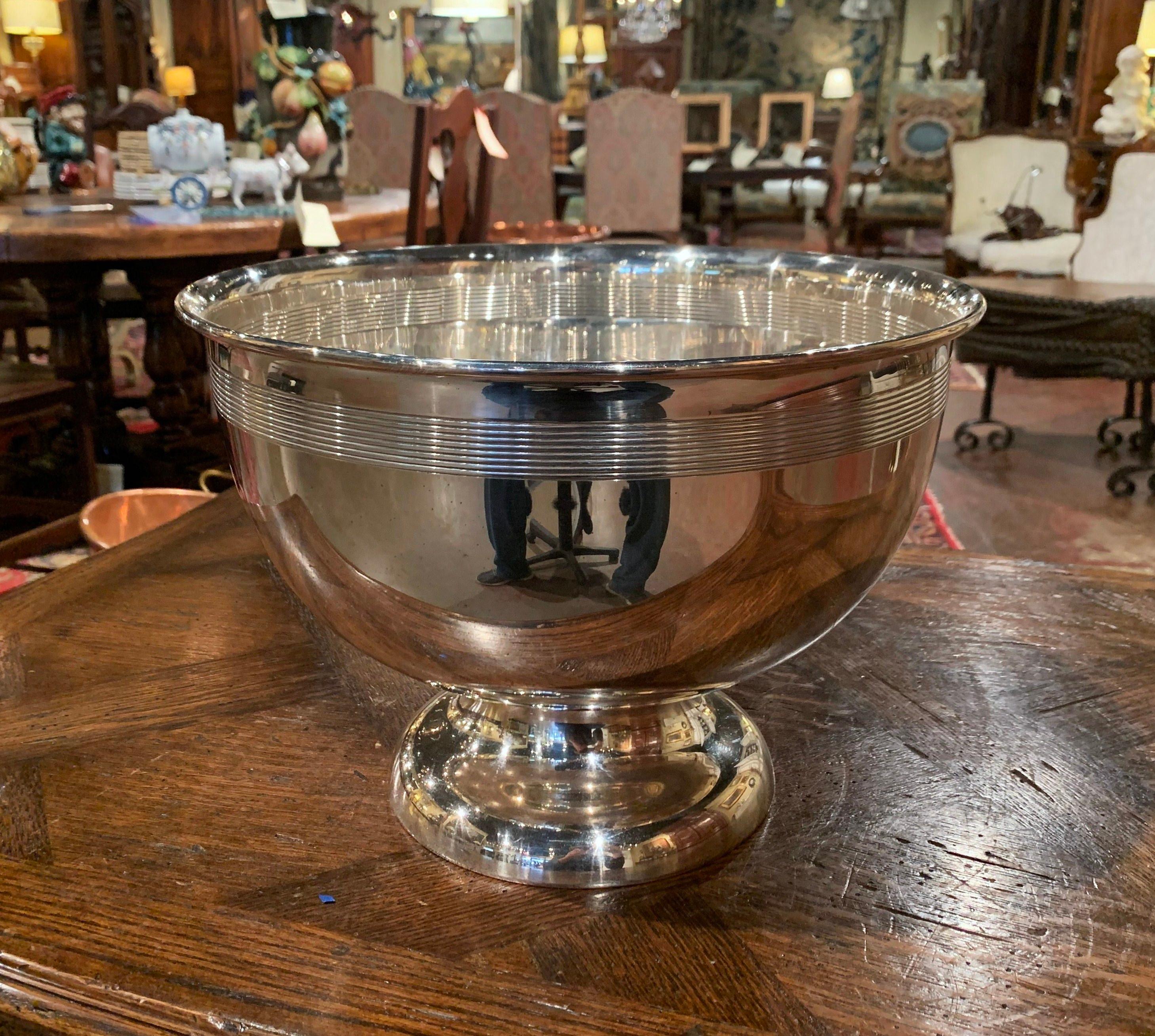Keep your wine or champagne chilled in style with this elegant round bowl; crafted in France, circa 1970 and made of silver plated over brass, the circular bowl stands on a round base. The bowl is in excellent condition with a rich patinated