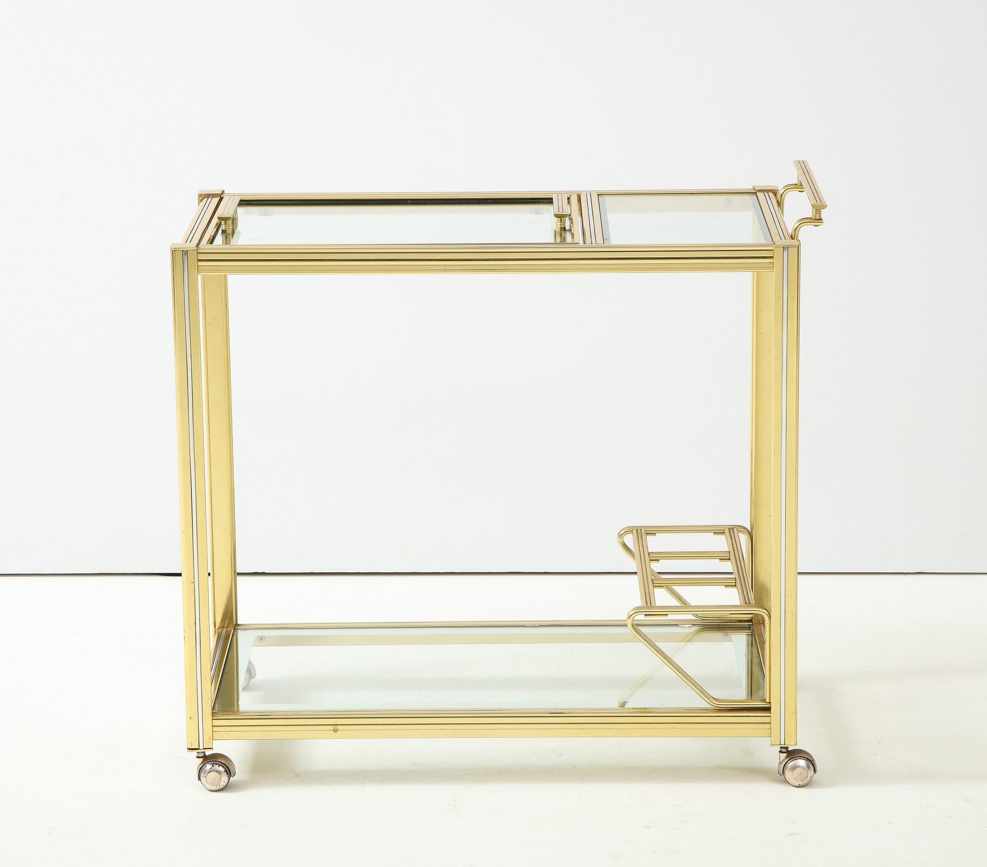 An mid 20th century brass and glass bar cart or trolley from France. The top shelf has a lift-out tray with handles, making this a unique and special cart. Perfect for entertaining, the lower shelf hase a three bottle holder. Four working casters.