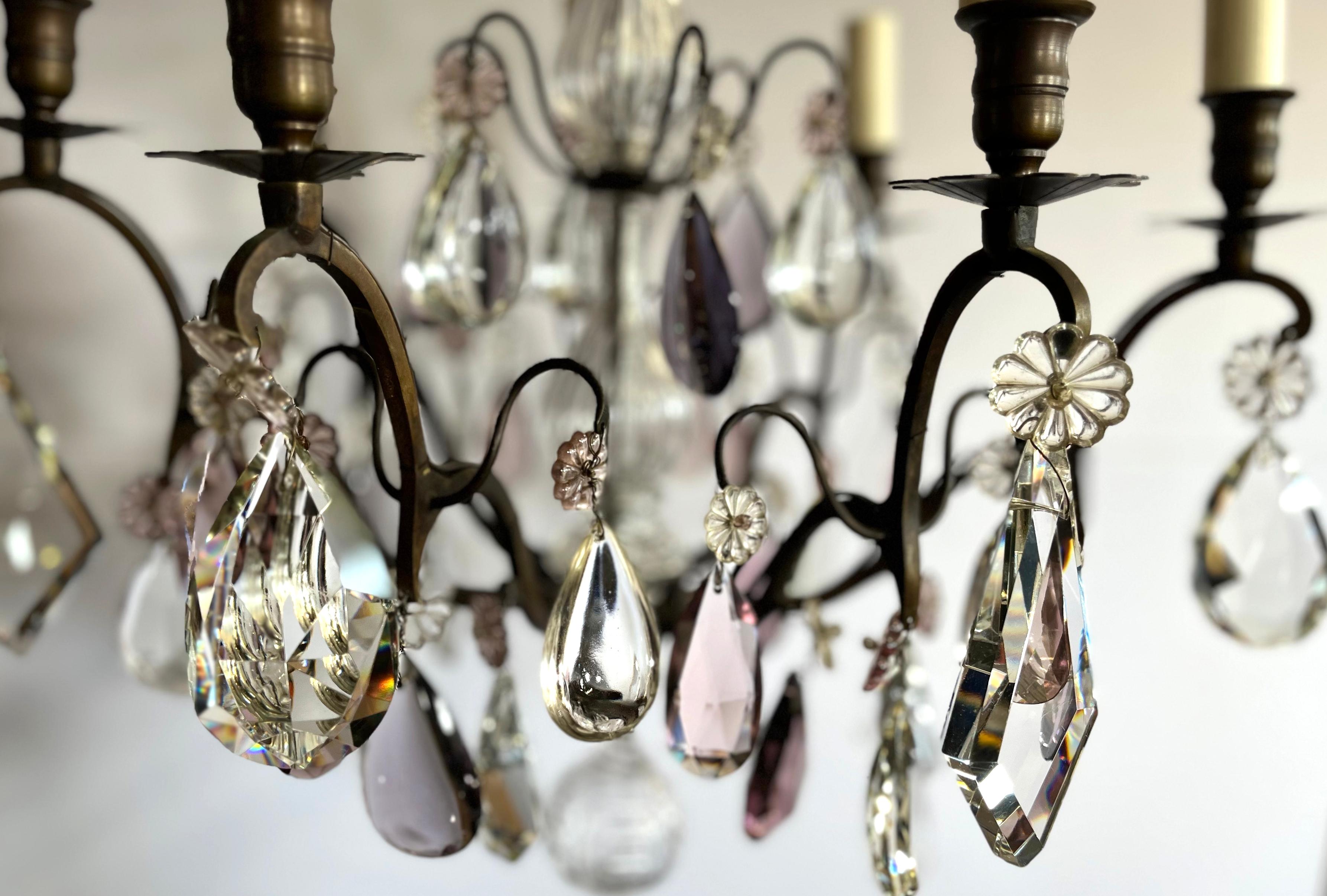 Lustre français du milieu du 20e siècle à sept lumières en cristal avec une monture en bronze foncé patiné. Les bras feuillagés sont ornés de gouttes d'améthyste en forme de poire à facettes. Décorée d'une tige centrale en verre strié, de flèches en