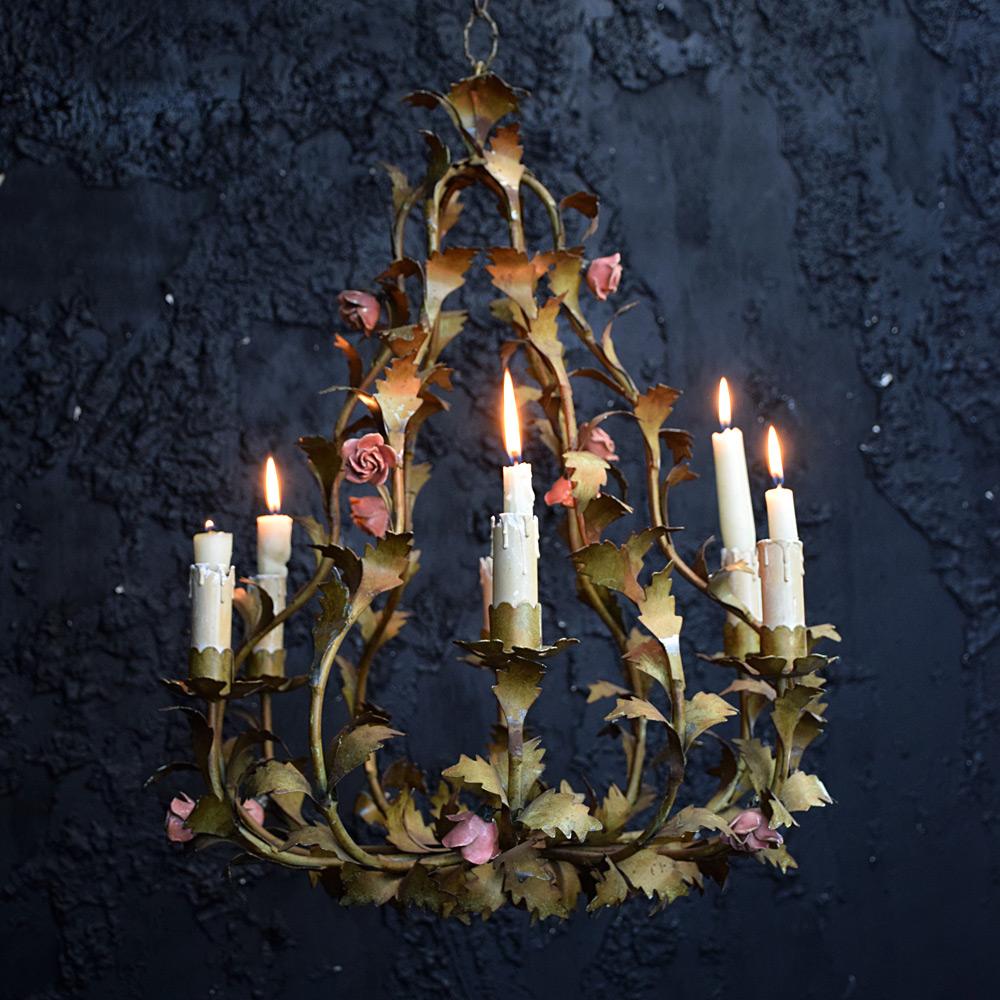 Mid-20th century French chandelier 

Made from toleware/metal and ceramic this mid-20th century hand crafted French chandelier details lots of floral and leaf sections. With numerous ceramic flowers scattered across this light. With its original