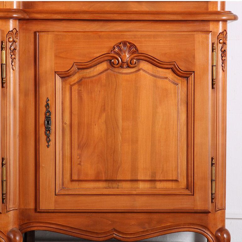 French Louis XV style breakfront cherry wood bookcase with adjustable shelves in the three upper glass-front sections and lower storage behind three paneled doors. A lovely-quality French-made piece- solid cherry throughout with paneled sides,