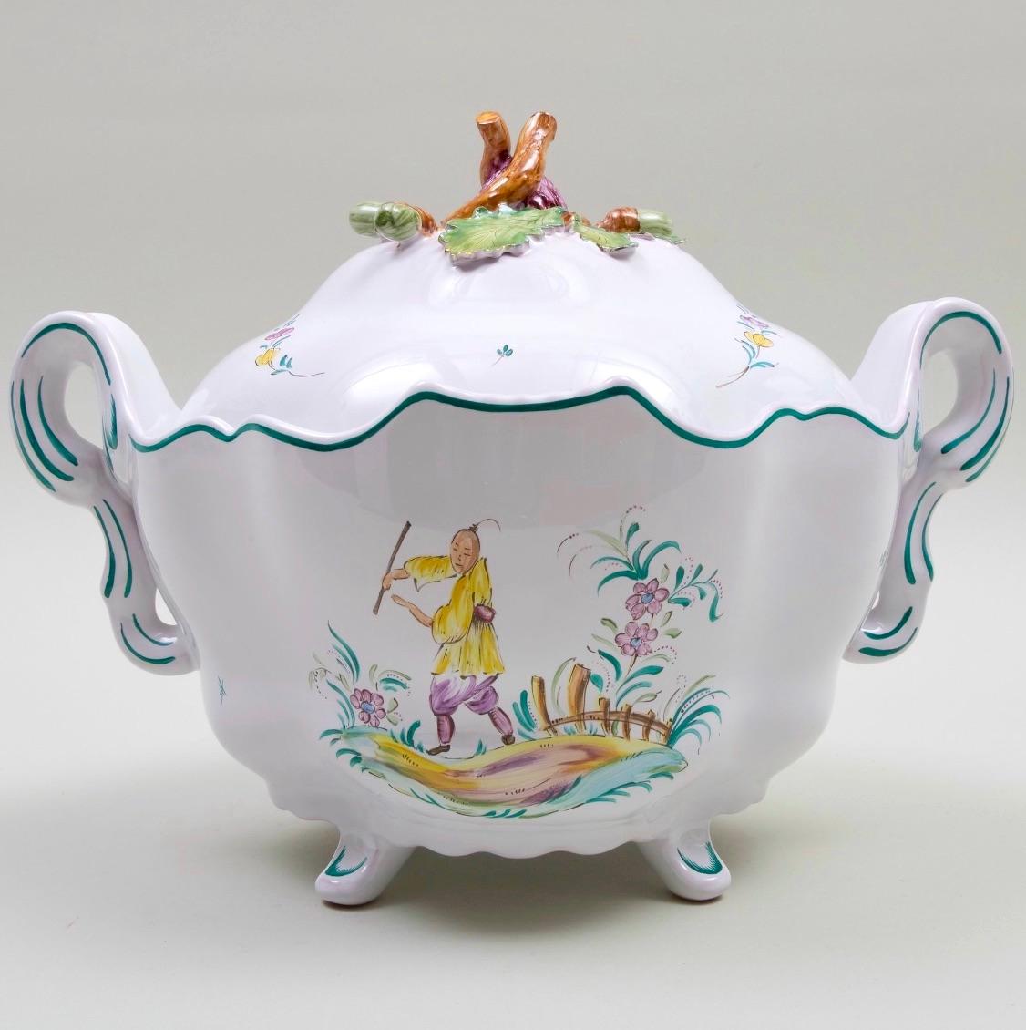 Esta exquisita sopera francesa de loza de mediados del siglo XX, obra de Sègries Moustiers, es un impresionante ejemplo de artesanía y arte tradicionales. Perfecta como vajilla o servicio de mesa, la sopera de dos piezas muestra motivos de