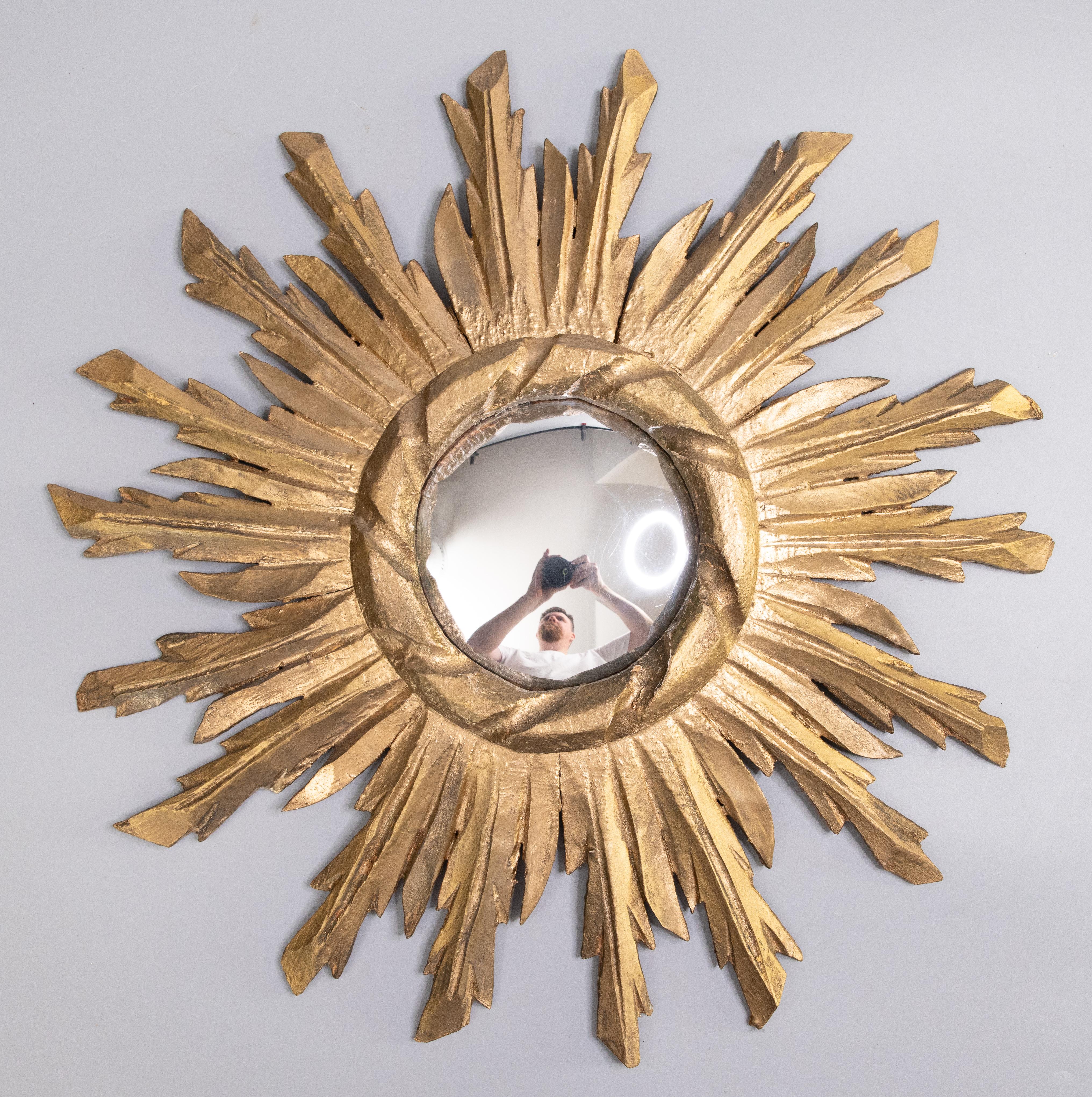 A stunning vintage French gilded wood sunburst or starburst mirror, circa 1950. It retains the original convex mirror which is surrounded by hand carved rays of alternating lengths with a lovely gilt patina.

DIMENSIONS
17