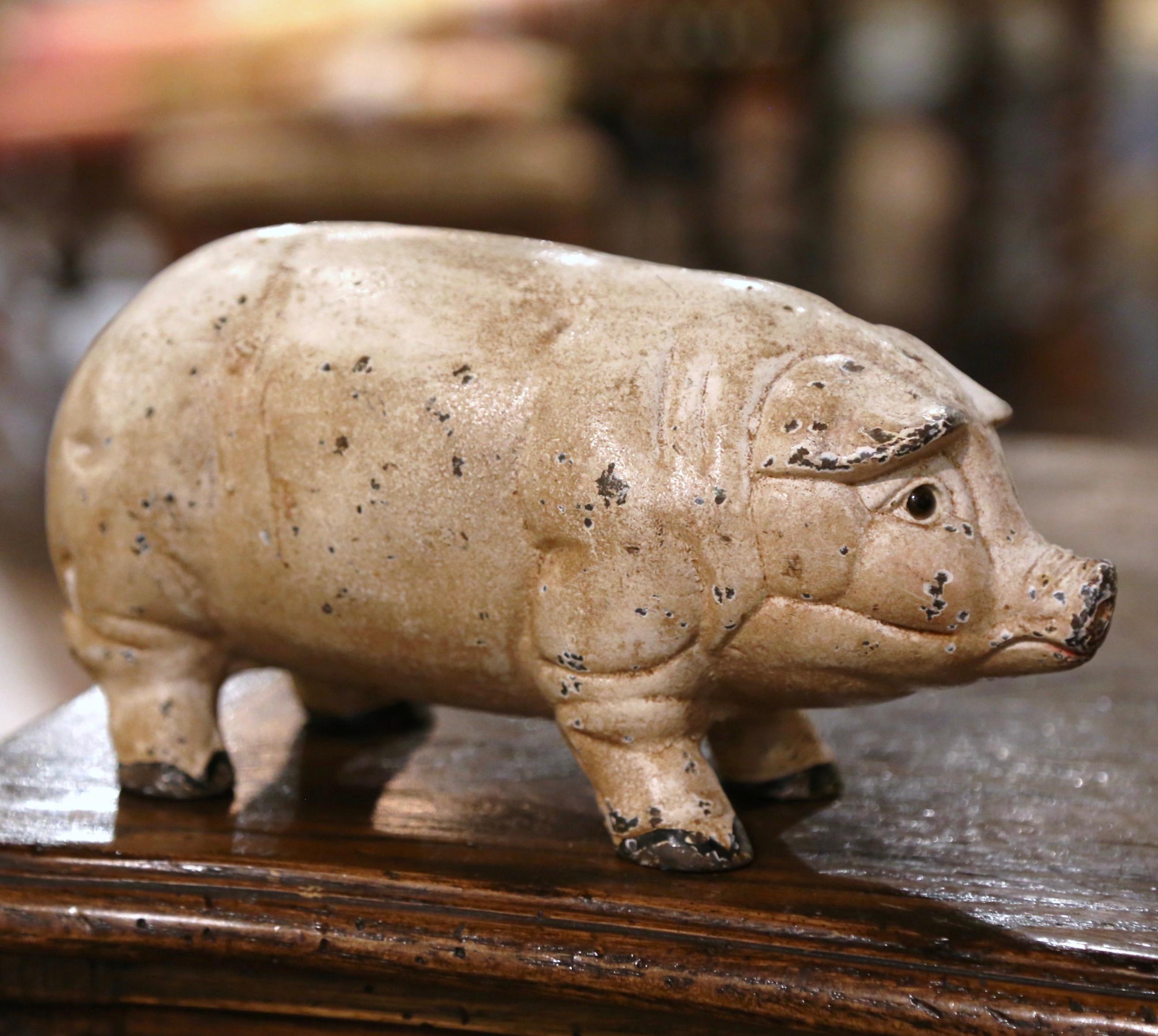 Decorate a kitchen counter with this vintage iron pig sculpture. Crafted in France, circa 1960, the hand painted pig is dressed with a slot for coins at the pediment; with very realistic shape and detail, the piggy bank has a beautiful beige rubbed