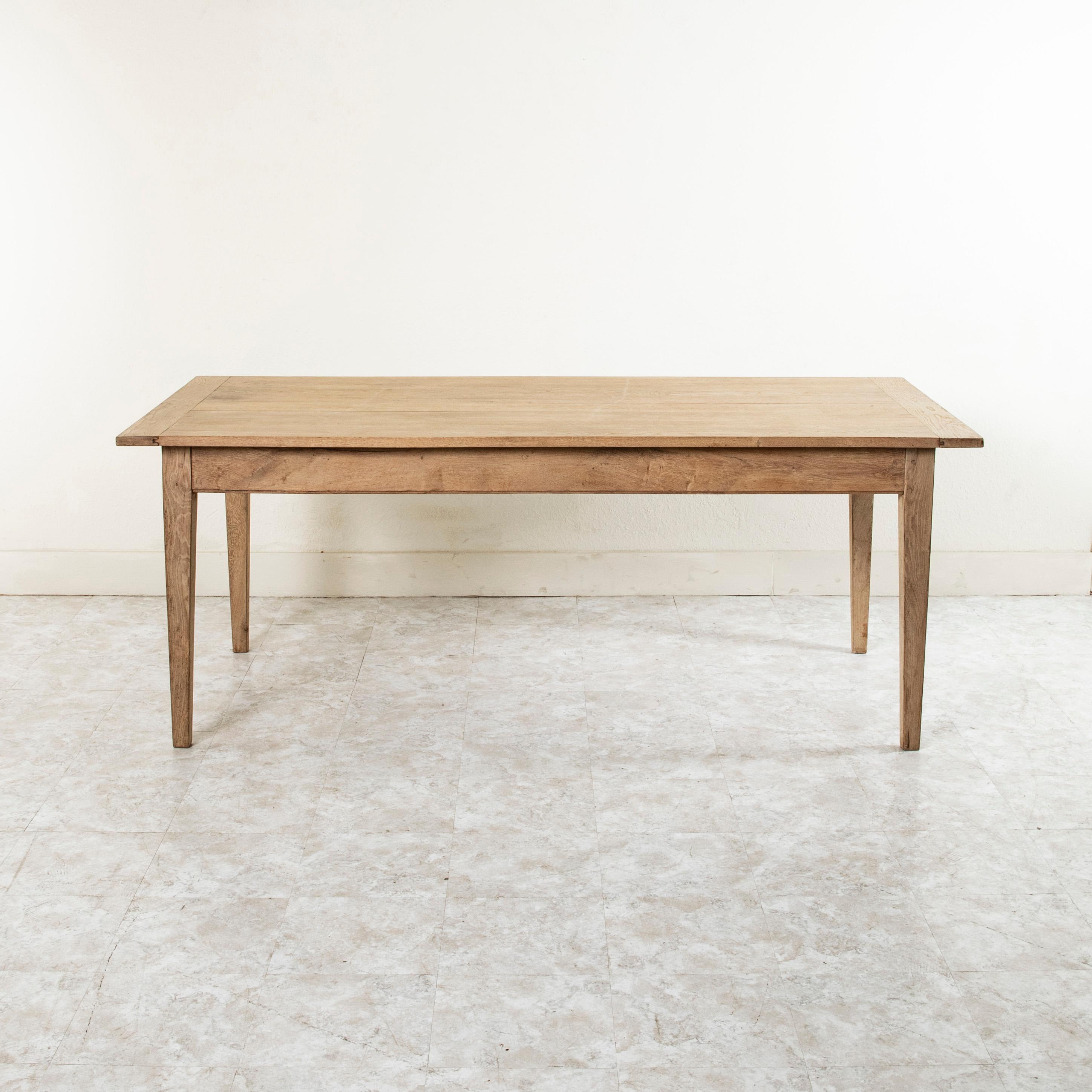 From the region of Le Perche in Normandy, France, this mid twentieth century bleached oak farm table or dining table features a single drawer at one end originally used to store the bread knife used to cut baguettes, a staple at every French meal.