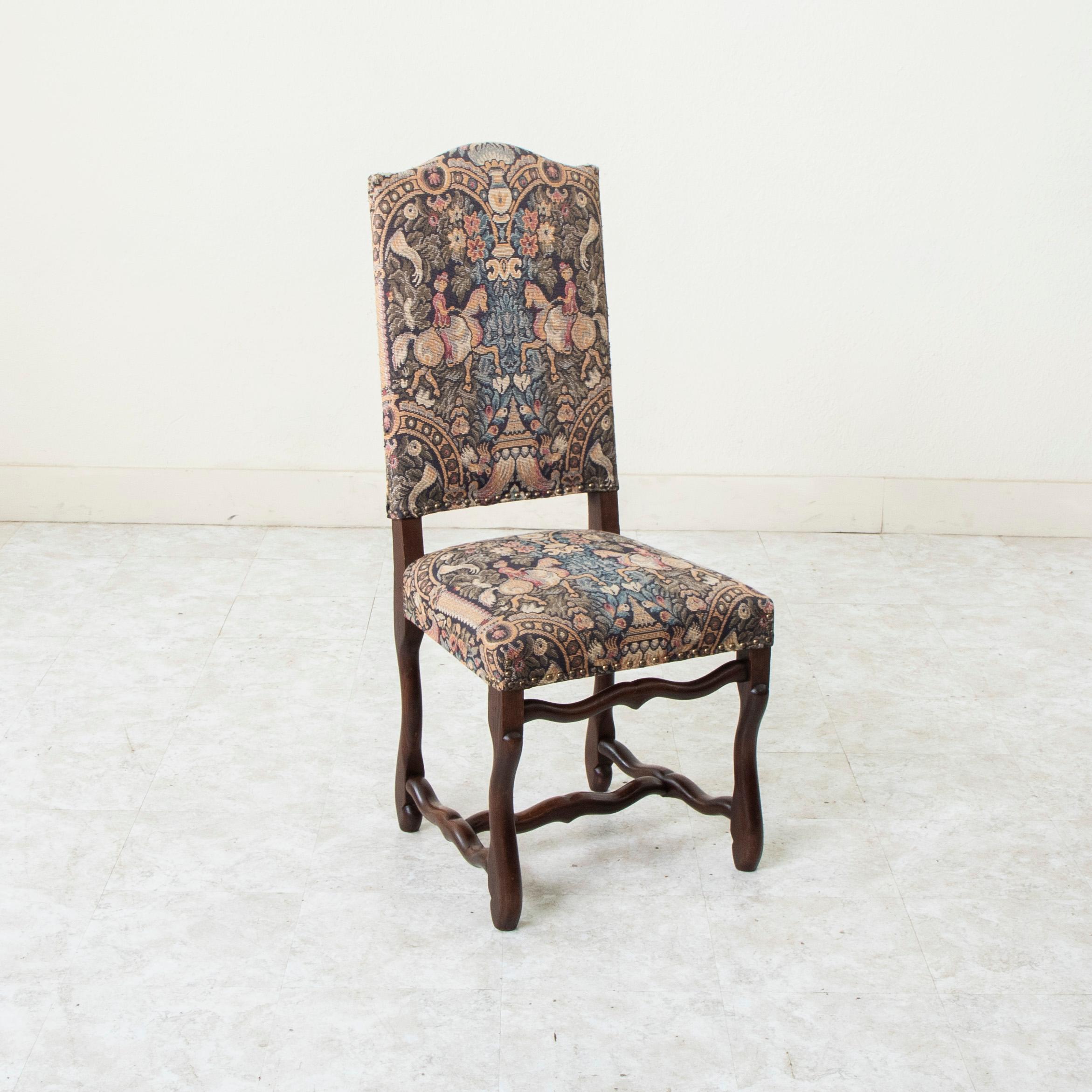 This set of six French oak mutton leg side chairs or dining chairs from the mid twentieth century are of hand pegged construction. These tall dining chairs with arched backs are upholstered in tapestries depicting female horse riders and are