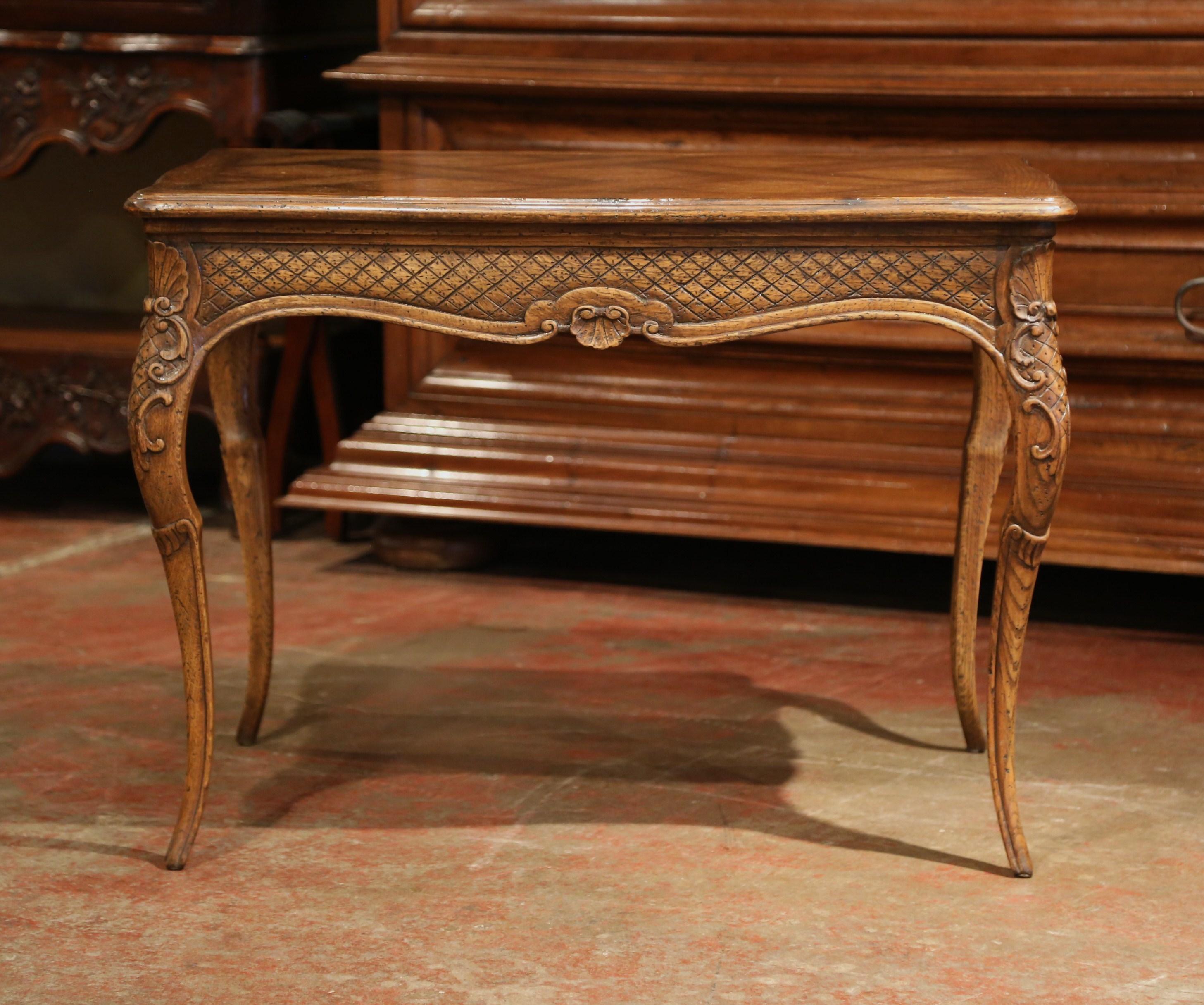 Place this elegant, Louis XV carved side table next to a sofa or between two armchairs in a living room. Crafted in Provence circa 1960, the end table sits on four cabriole legs, and features exquisite carvings throughout. The scalloped apron is