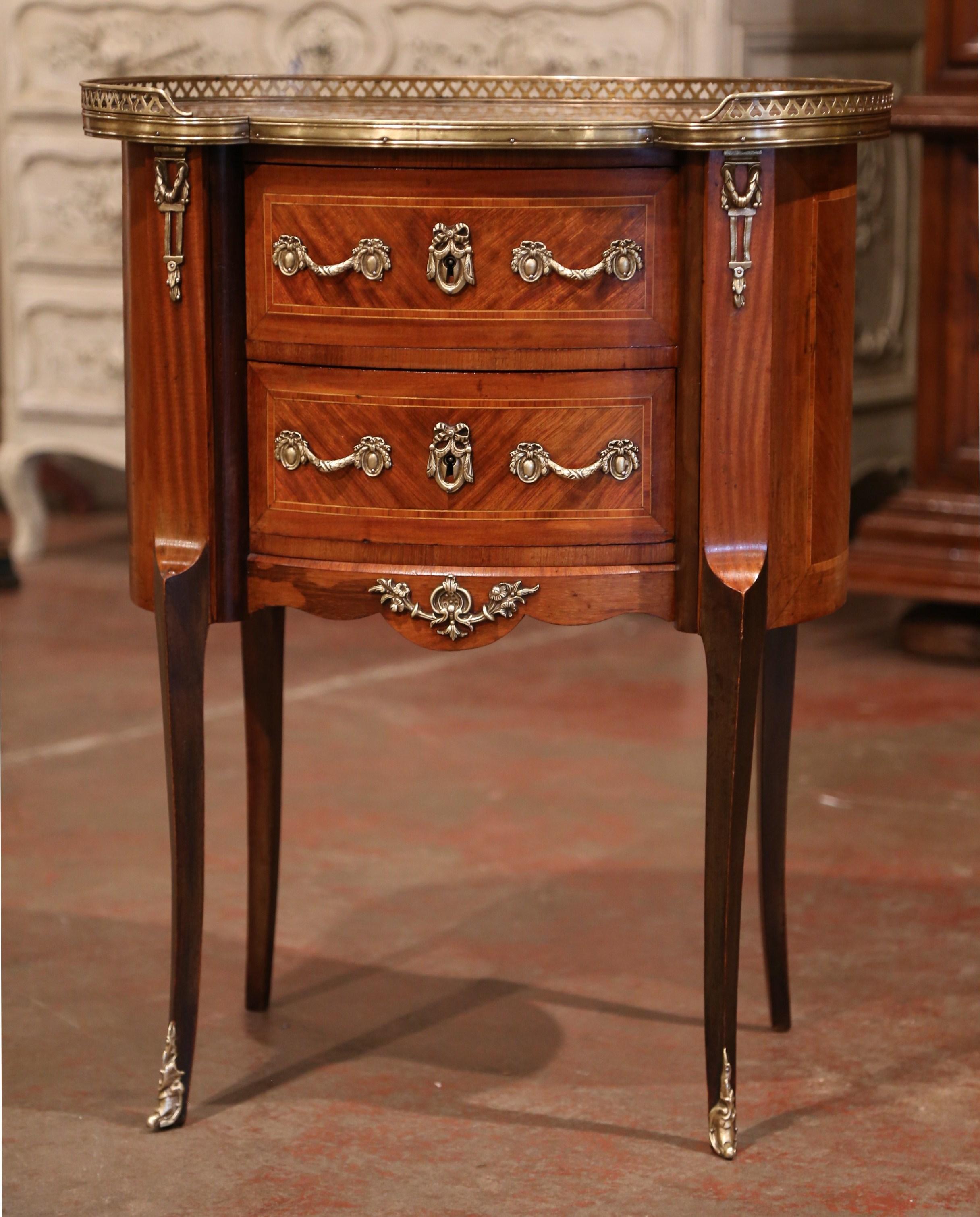 This elegant, kidney-shaped fruitwood antique commode was crafted in Paris, circa 1950. Versatile, the oval petite cabinet could be used as a bedside table, a side table next to an armchair, or as a small storage cabinet in a powder room. The