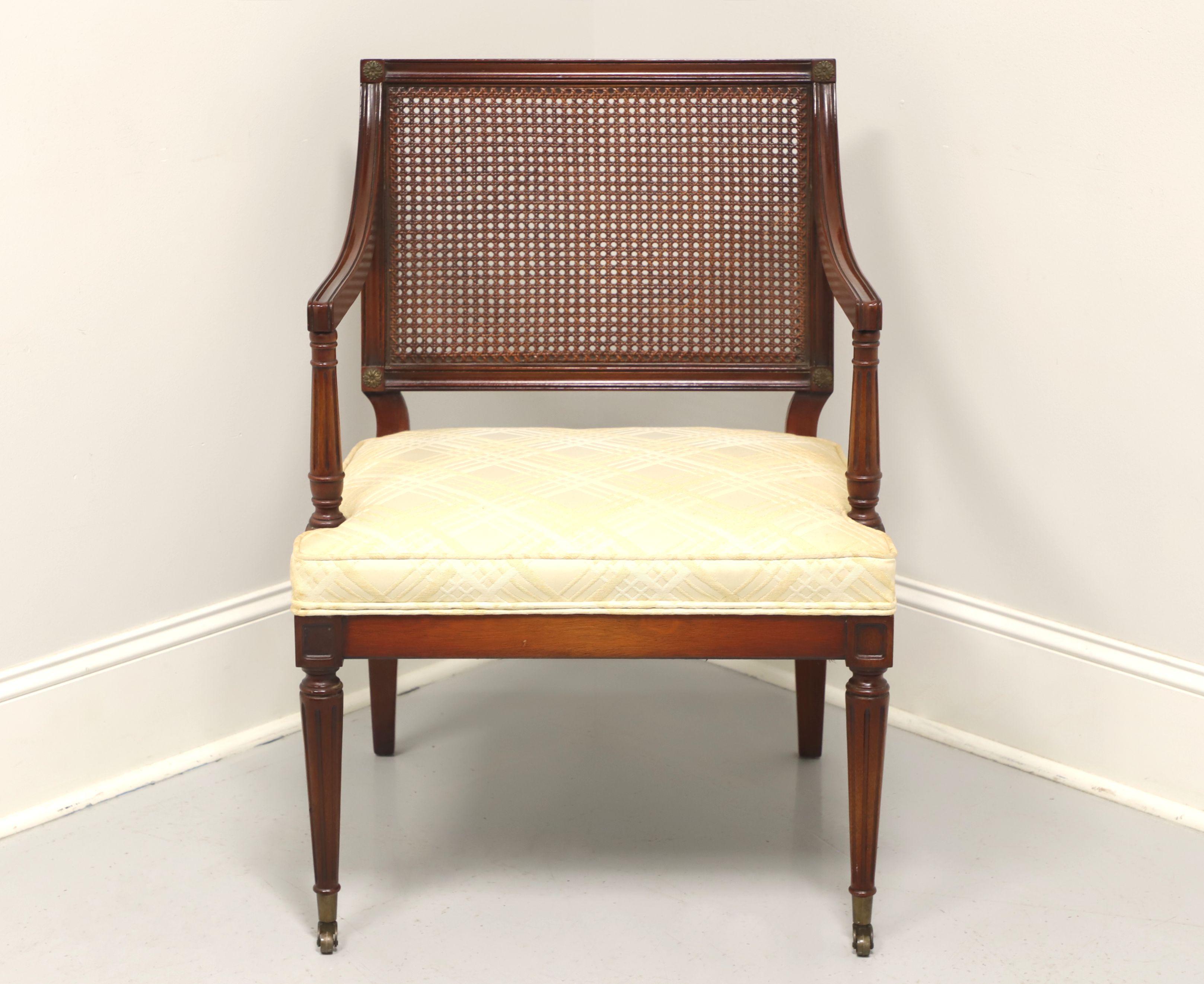 A French Provincial Louis XVI armchair, unbranded, similar quality to Henredon. Mahogany with cane back, fluted arms, neutral fabric upholstered seat, tapered fluted front legs on brass casters. Made in the USA, in the mid 20th Century.

Measures: