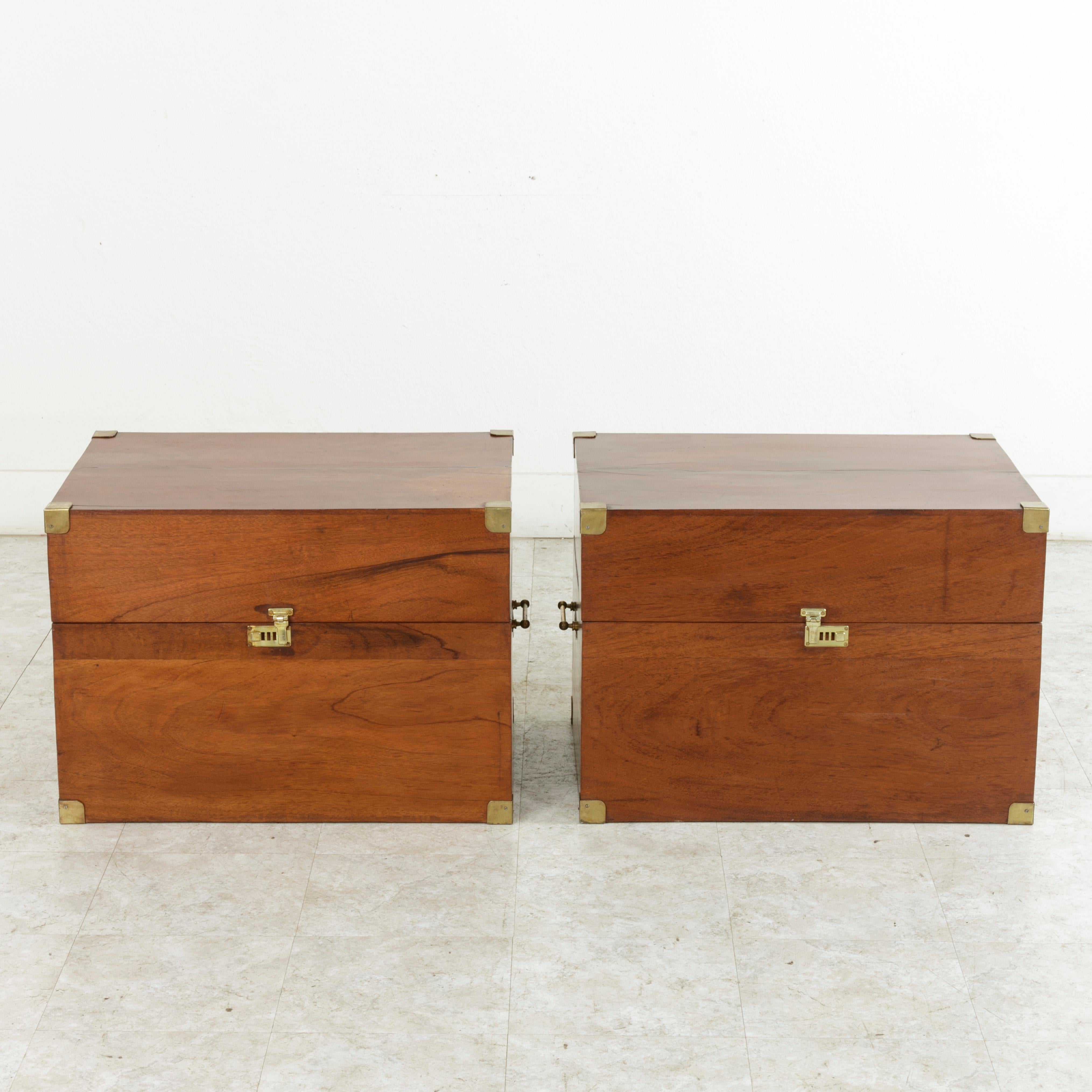 This pair of mid-20th century French naval officer's traveling trunks is constructed of solid mahogany and features brass corners, handles, and latches. Each chest has its own unique interior with leather straps, one with a lift out tray lined in