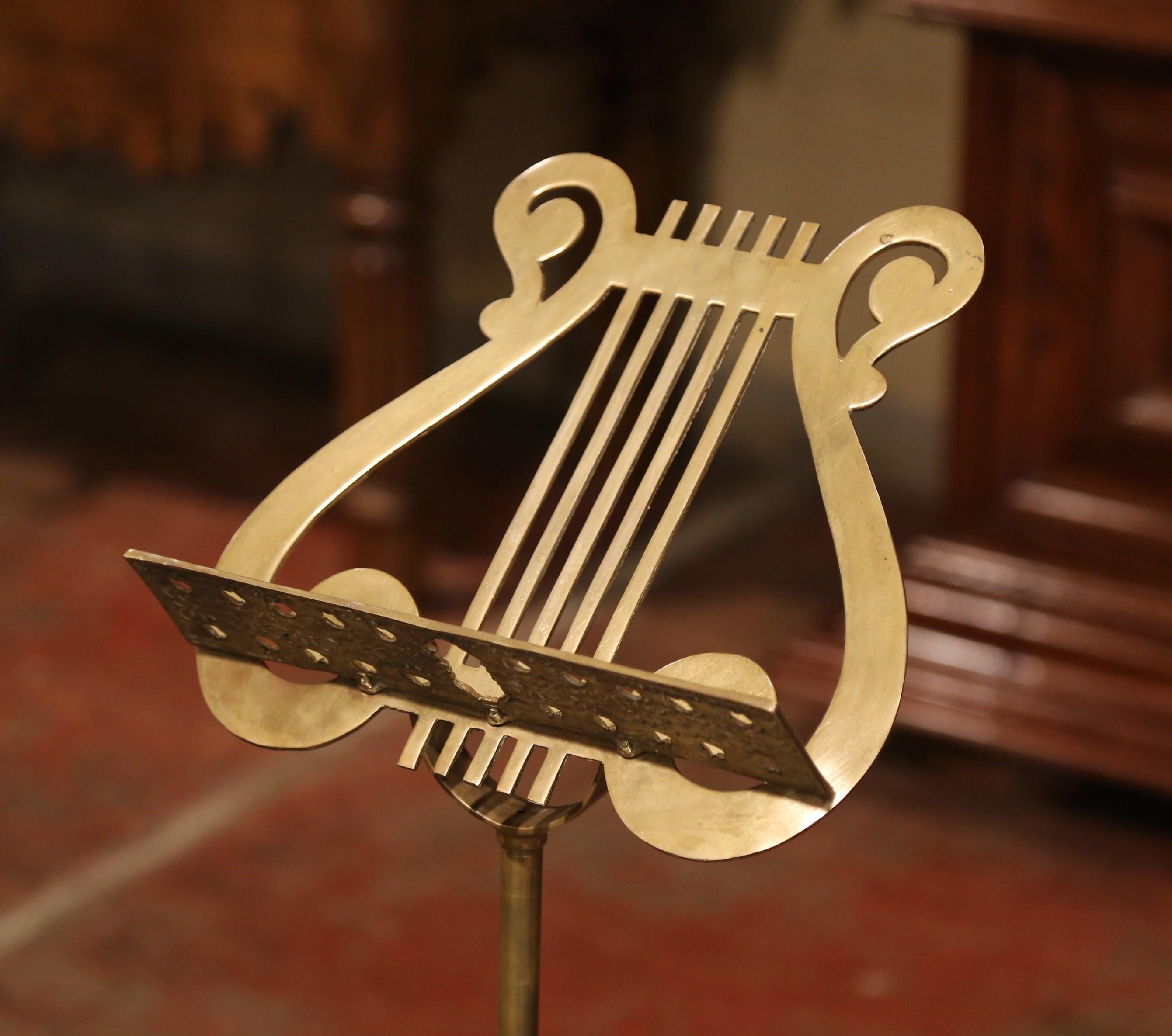 Display your music score or a book on this decorative, antique stand! Crafted in France, circa 1950, the music stand sits on four feet base decorated with floral motifs, and features an intricate design with a lyre decor over the book holder. The