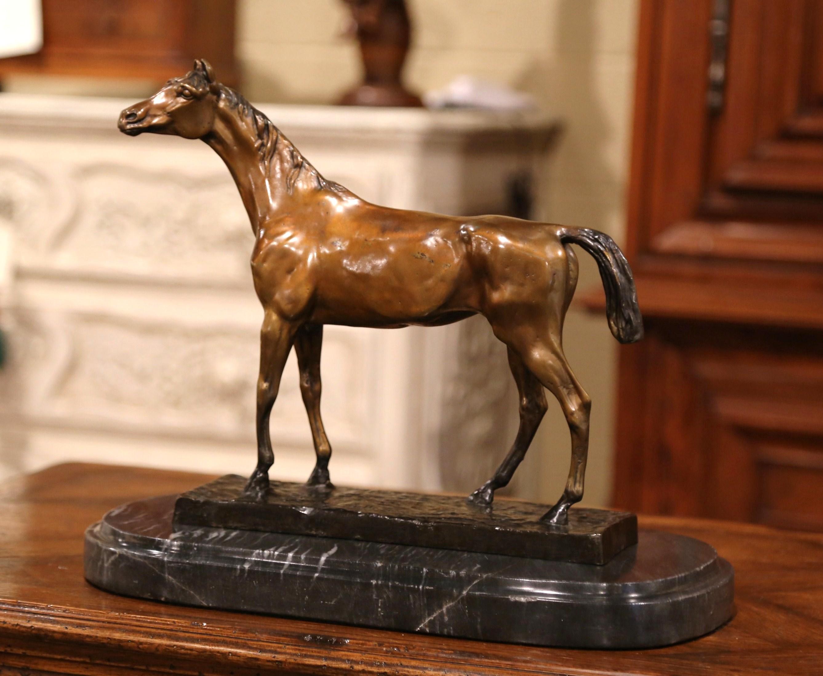 Decorate a man's office or library shelf with this elegant bronze horse sculpture, created in France circa 1950, the sculpture is highly detailed depicting a race horse standing on an oval black and grey marble base. The piece is in excellent