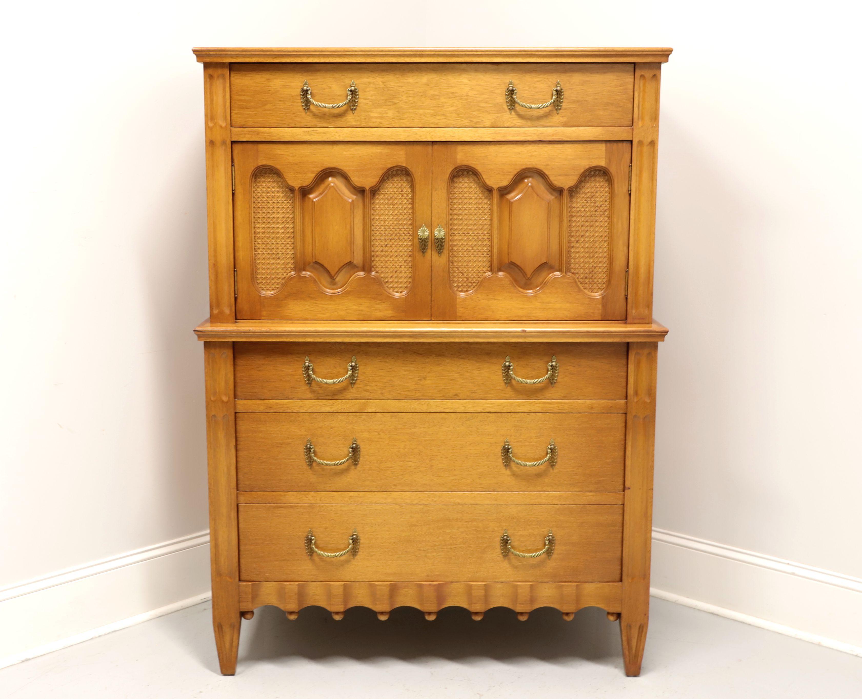 A French Provincial Louis XVI style chest on chest, unbranded. Hardwood with decorative brass hardware, fluted sides, cane inserts to door panels, decorative apron and tapered legs. Features upper portion with one dovetail drawer over a two door
