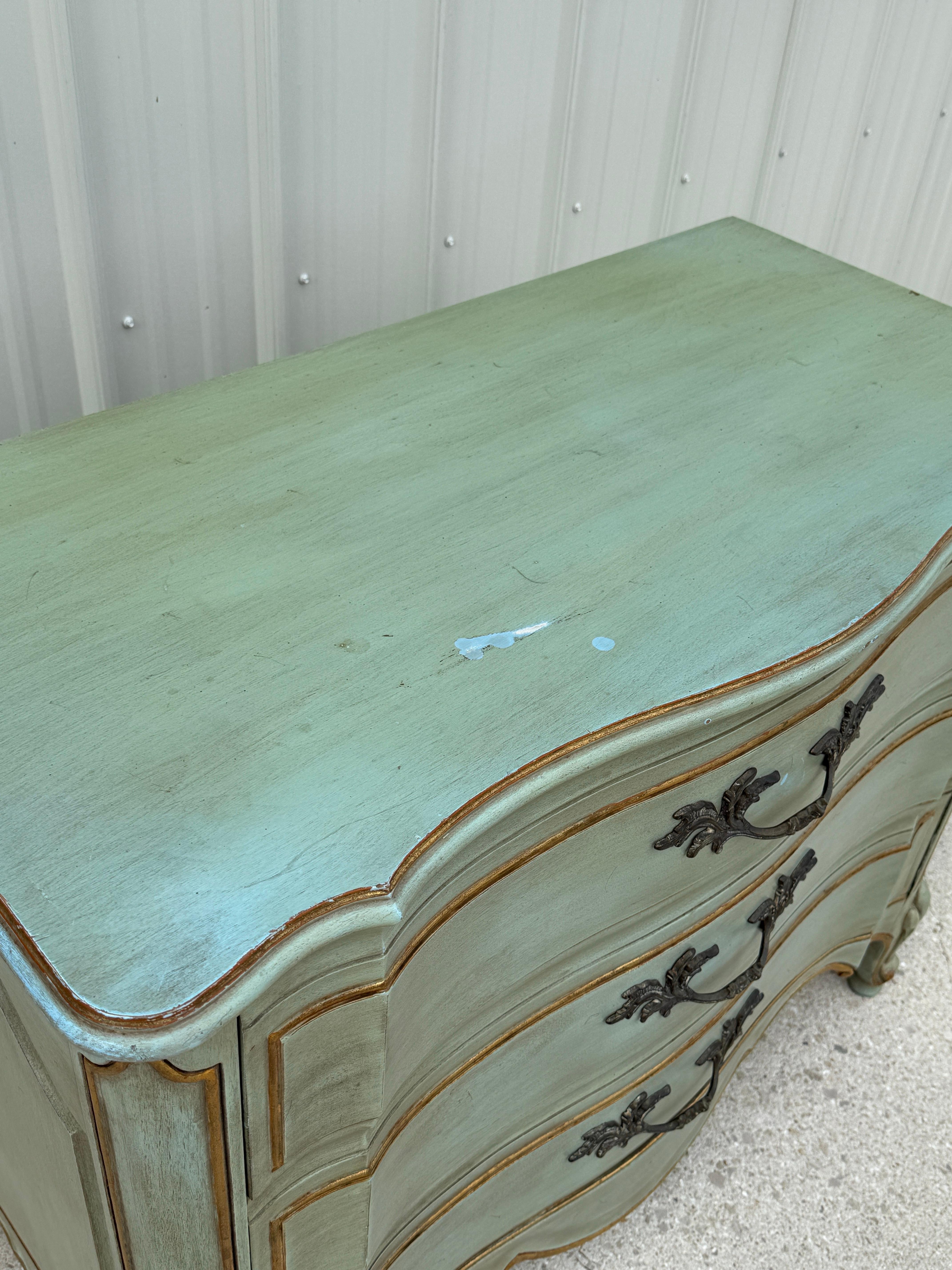 Questa splendida cassapanca di Mid Century Antiques French Bombay di Karges è una vera e propria opera d'arte, caratterizzata da una silhouette graziosamente curva e da un'elegante finitura dipinta a mano in un morbido verde anticato con il giusto