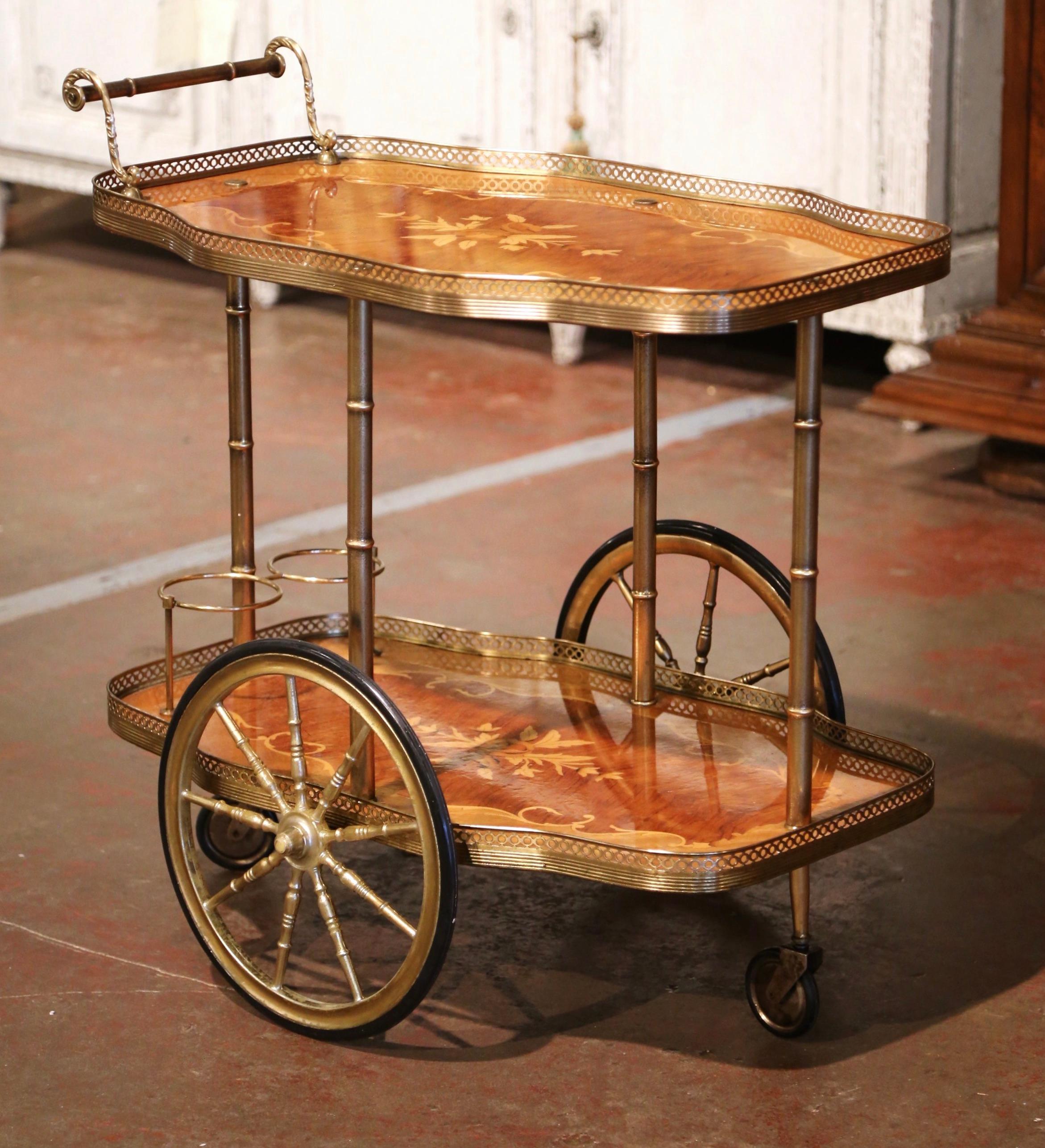 This elegant two-tier wooden and brass cart was created in France, circa 1950. Scalloped in shape, the bar cart sits on side spoke wheels over bamboo shaped legs, and features a decorative handle at one end of the top deck. The two plateaus with