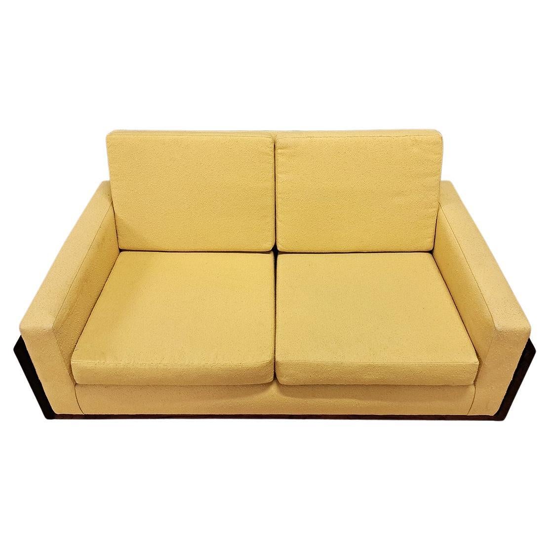 Elevate your interior with this elegant Mid-20th Century French two-seater sofa, expertly crafted from premium hardwood and upholstered in a light yellow bouclé fabric. This sofa embodies the timeless elegance of modern design, featuring clean,