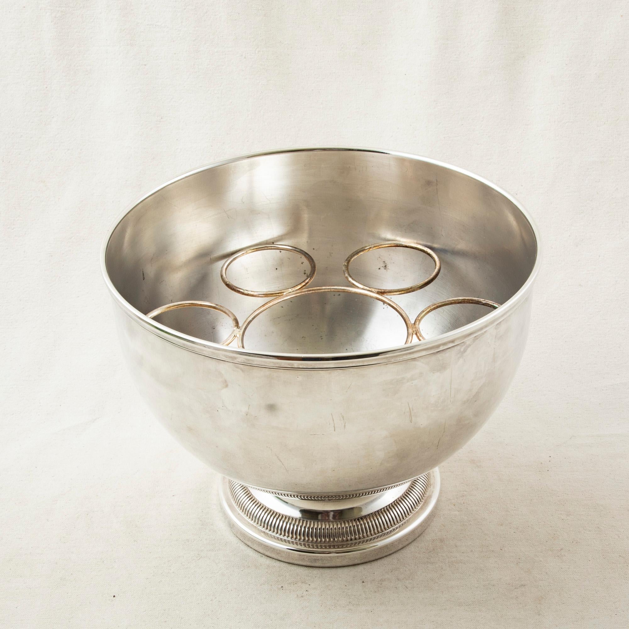 This mid-20th century French silver plate hotel champagne bucket or wine chiller features its original removable insert to hold a bottle and six champagne flutes. The bowl rests on a footed base. An ideal ice bucket for a dry bar, circa 1950.