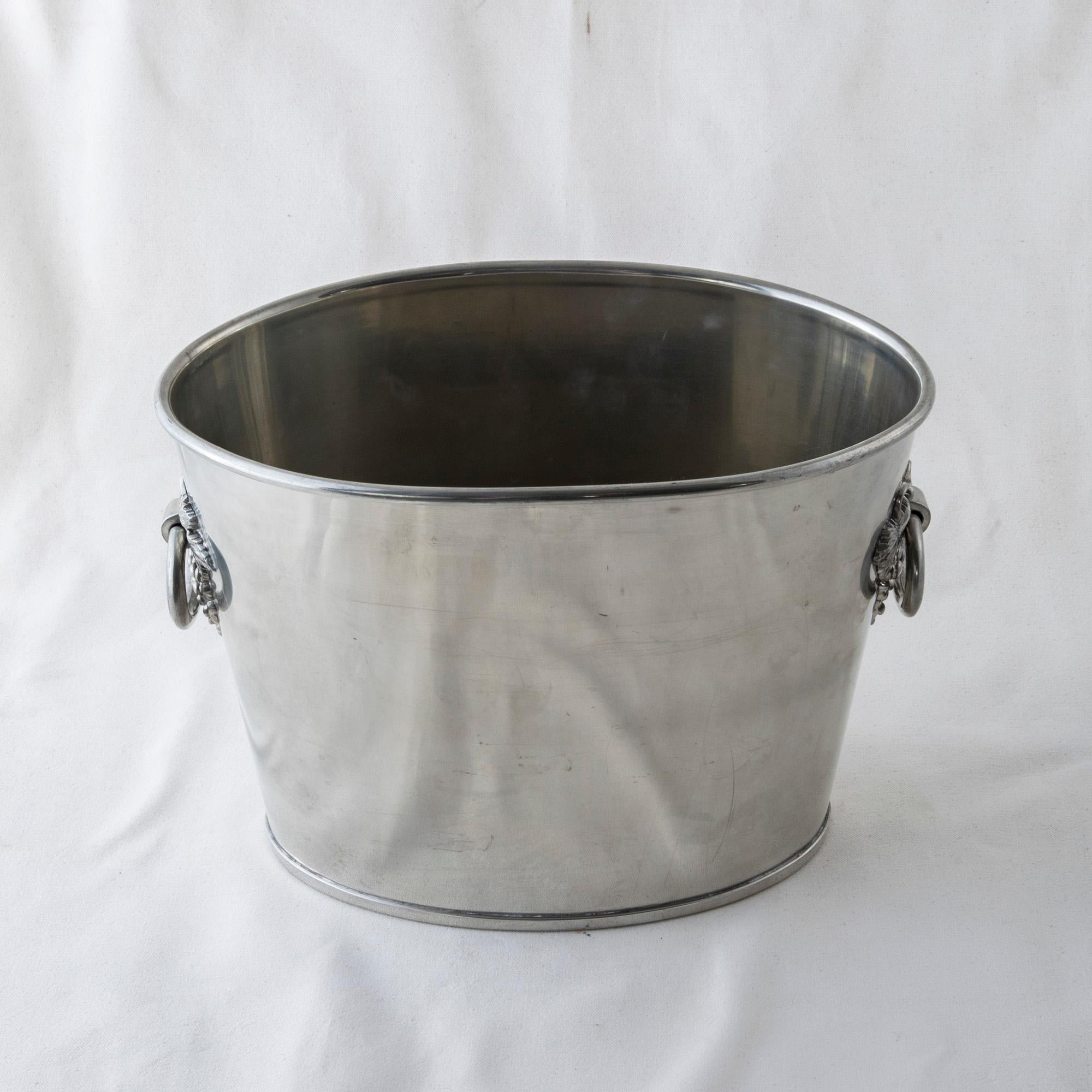 This midcentury French silverplate champagne bucket for two bottles features grapes and grape leaf handles. The bottom of the bucket is stamped by the maker Etains Dumanoir, or Dumanoir tin. The perfect addition to any dry bar, circa 1950.