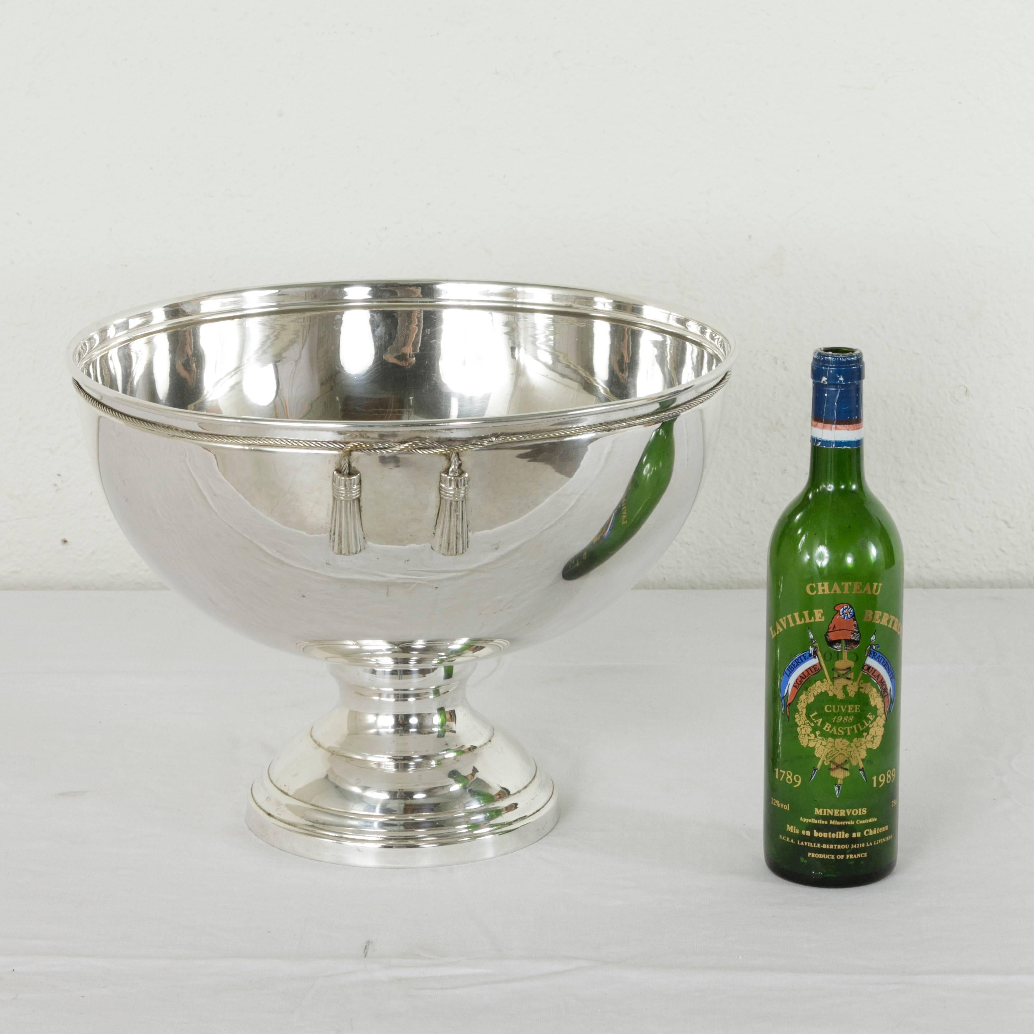 This mid-20th century French silver plate hotel champagne bucket features a twisted rope and tassel motif around its upper rim and can accommodate up to four bottles. The quintessential bar piece, this large champagne bucket is sure to lend elegance