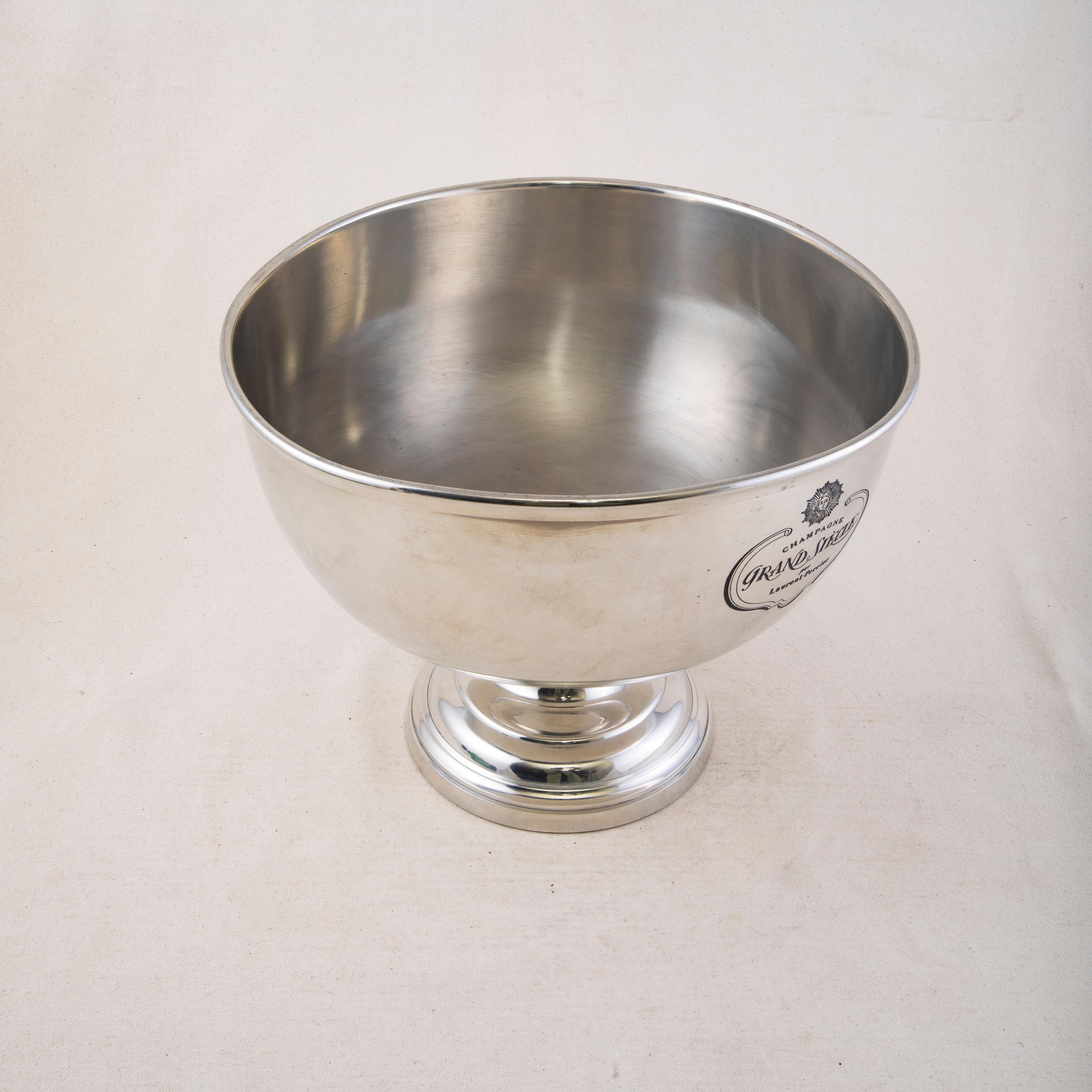 This mid twentieth century French silver plate over pewter hotel champagne bucket or wine chiller is engraved with the name of the champagne Grand Siecle par Laurent Perrier or by Laurent Perrier. Above the name is the head of Apollo the Greek god