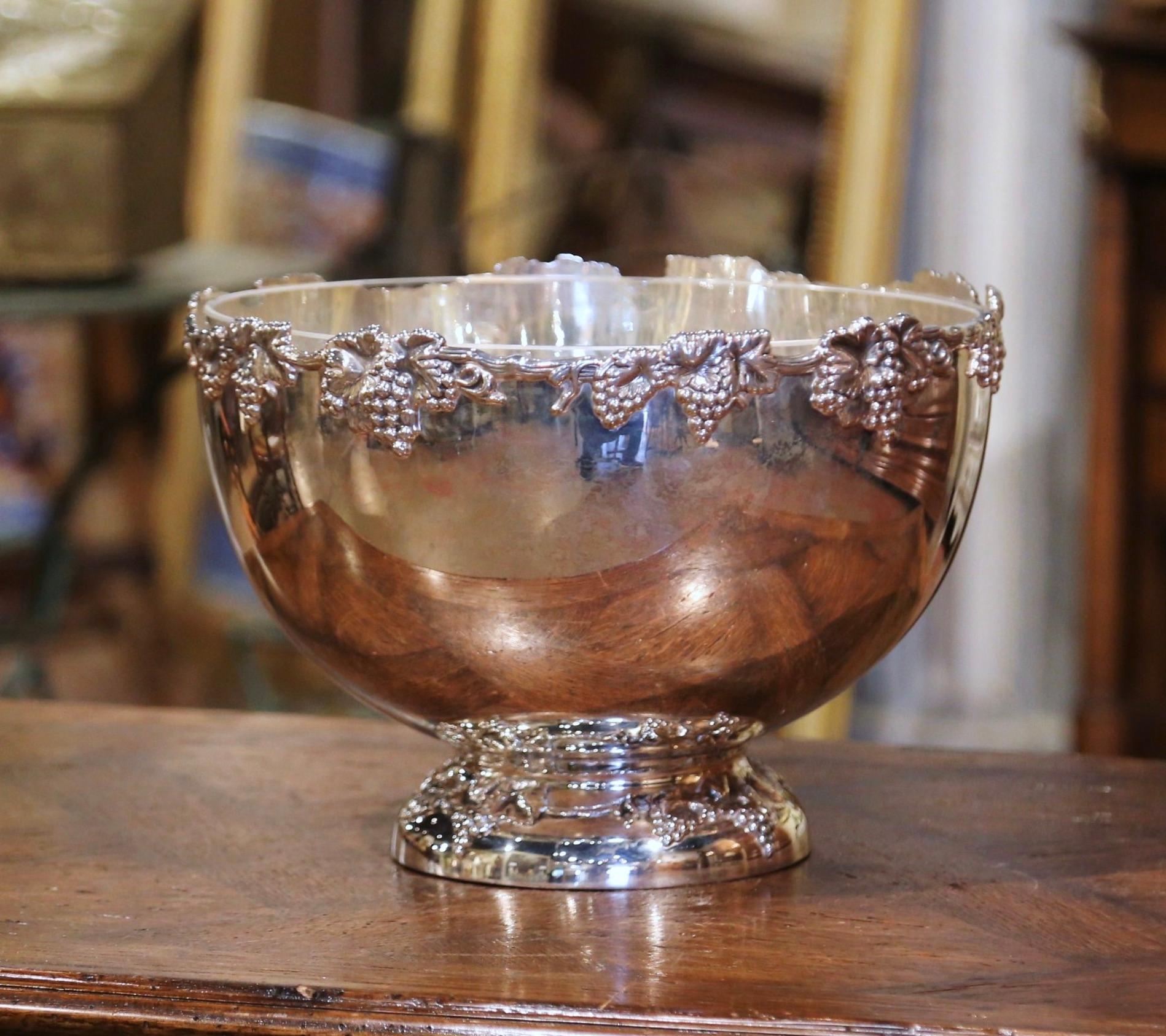 Keep your wine or champagne chilled in style with this elegant round bowl; crafted in France circa 1970 and made of silver plated metal, the circular bowl stands on a round base decorated with vine motifs; the scalloped rim is decorated with high