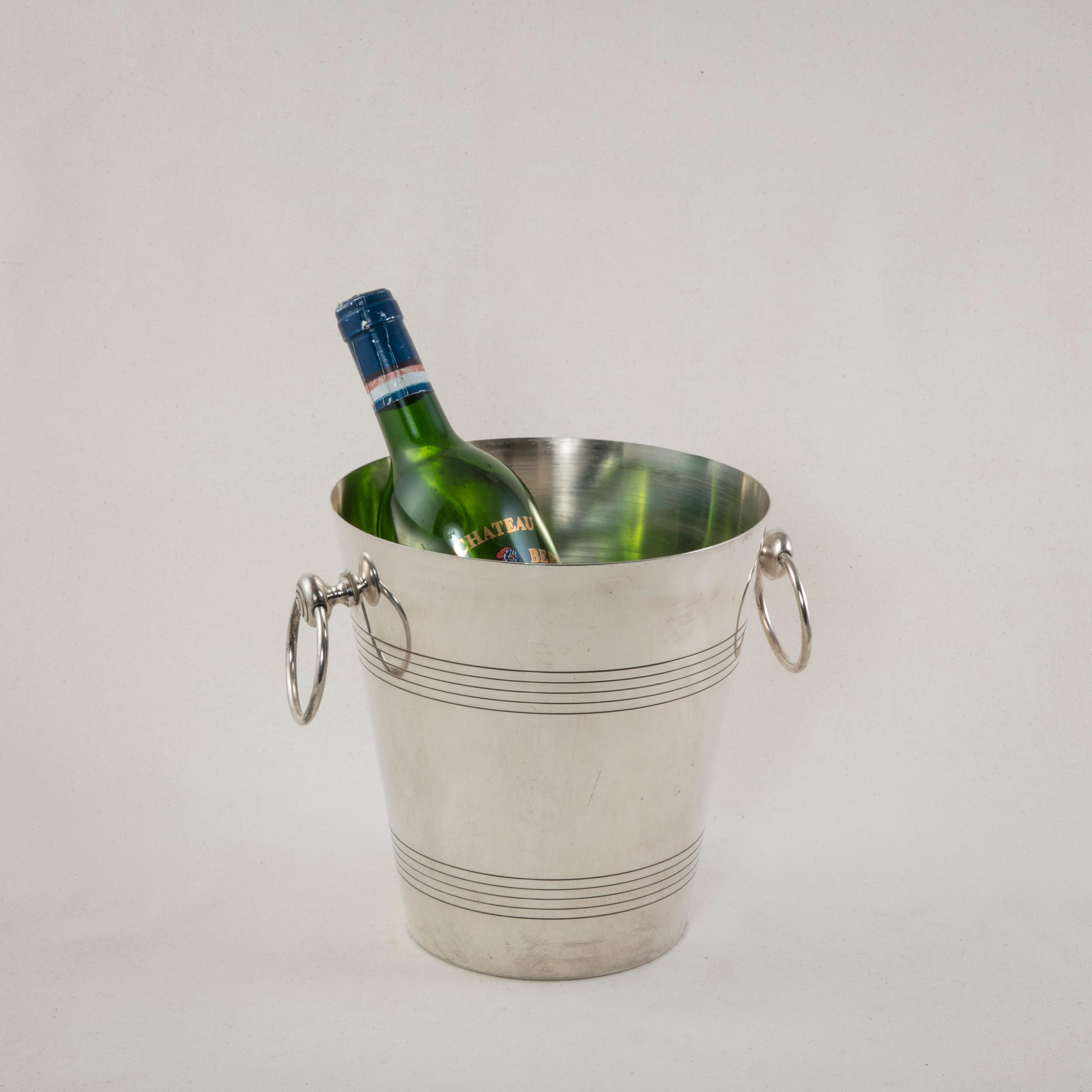 This mid-20th century French silver plate champagne bucket features concentric circles around the top and bottom. Two drop ring handles allow for easier carrying. A maker's hallmark is stamped on the bottom, circa 1950.