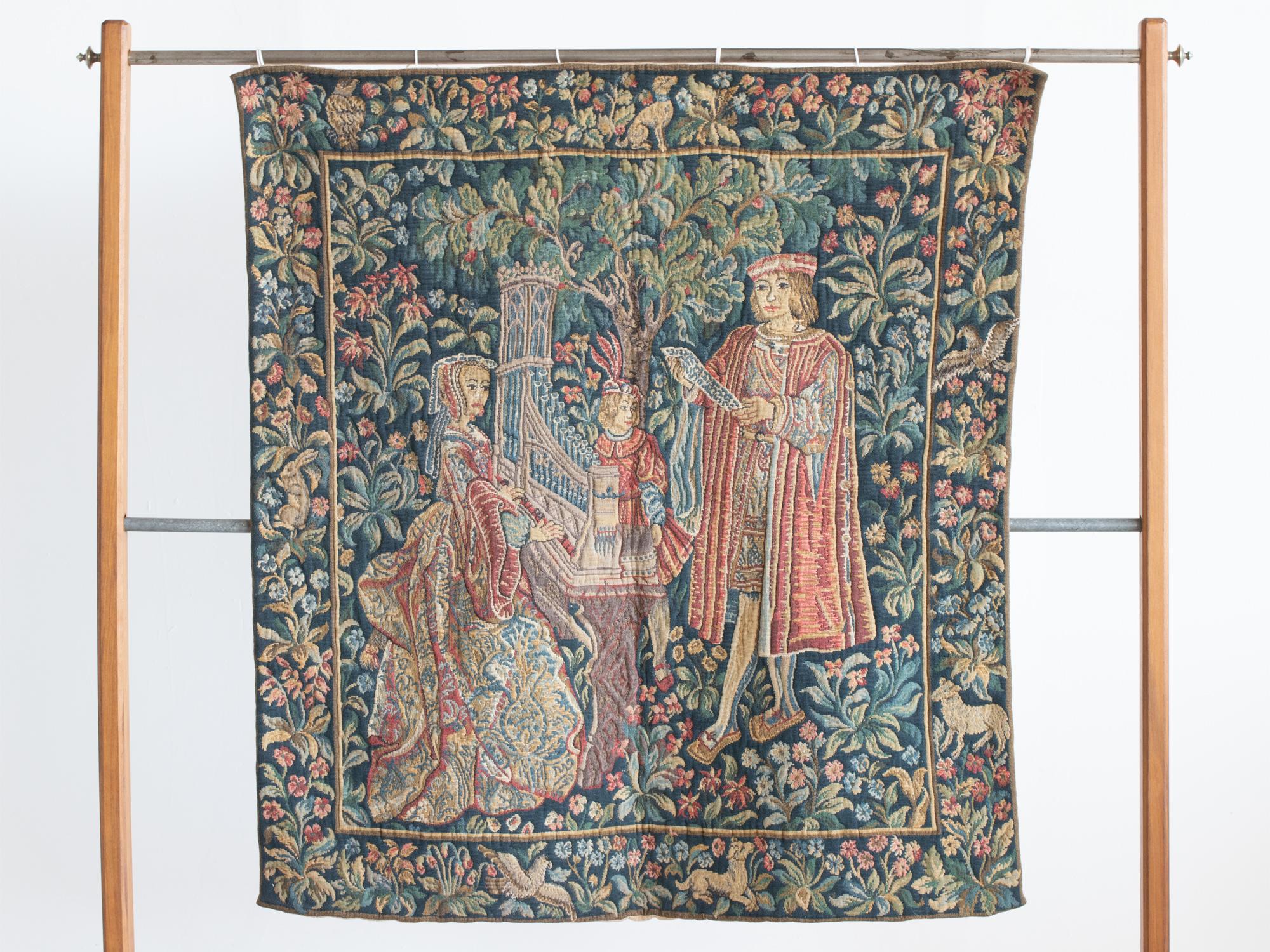 A tapestry wall hanging in the medieval taste. French, mid 20C.

Inspired by the work “La Dame à L'orgue”, part of the The Lady and Unicorn series, done in the Mille fleurs style in the late 15th century, today at the Angers castle.

In good order