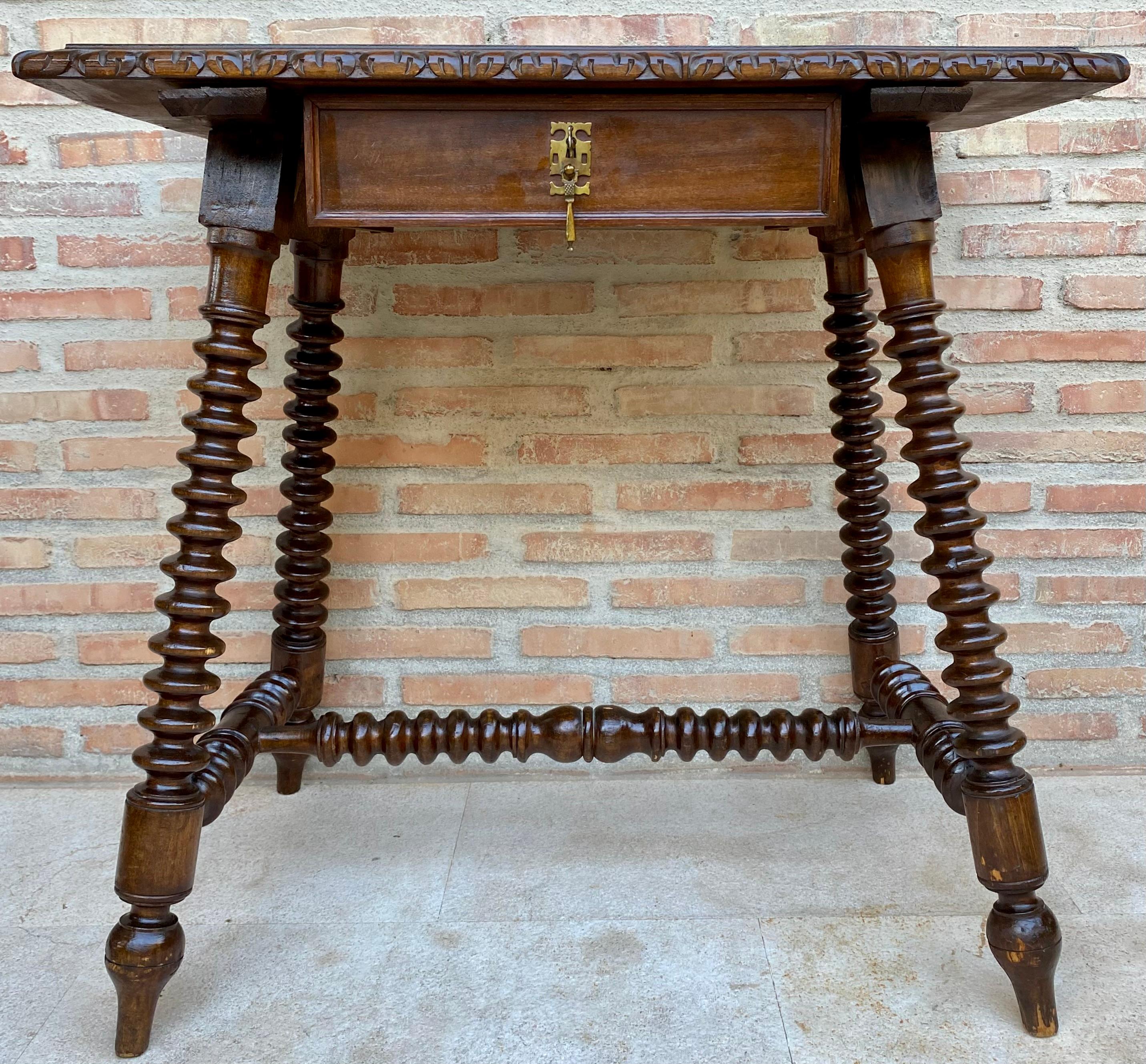 Mid-20th century French side table in carved walnut with a small front drawer with a bronze handle and a brass latch with its key supported by four turned legs joined by a turned stretcher.