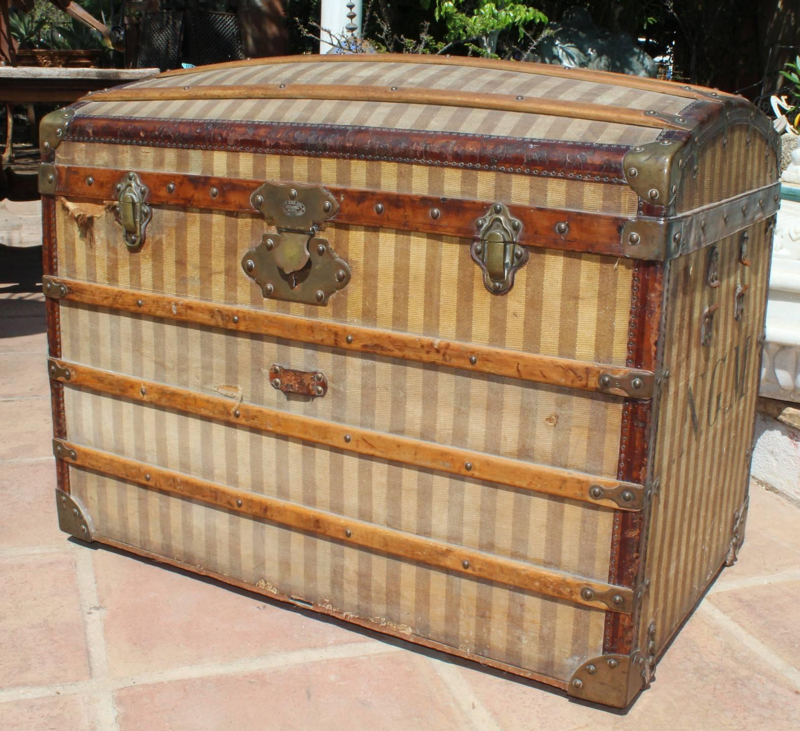 Mid-20th century, French wooden travel trunk with original striped upholstery and the owners initials engraved on the side. The front part has a plaque with the makers, Deraisme Paris and their full address. 


