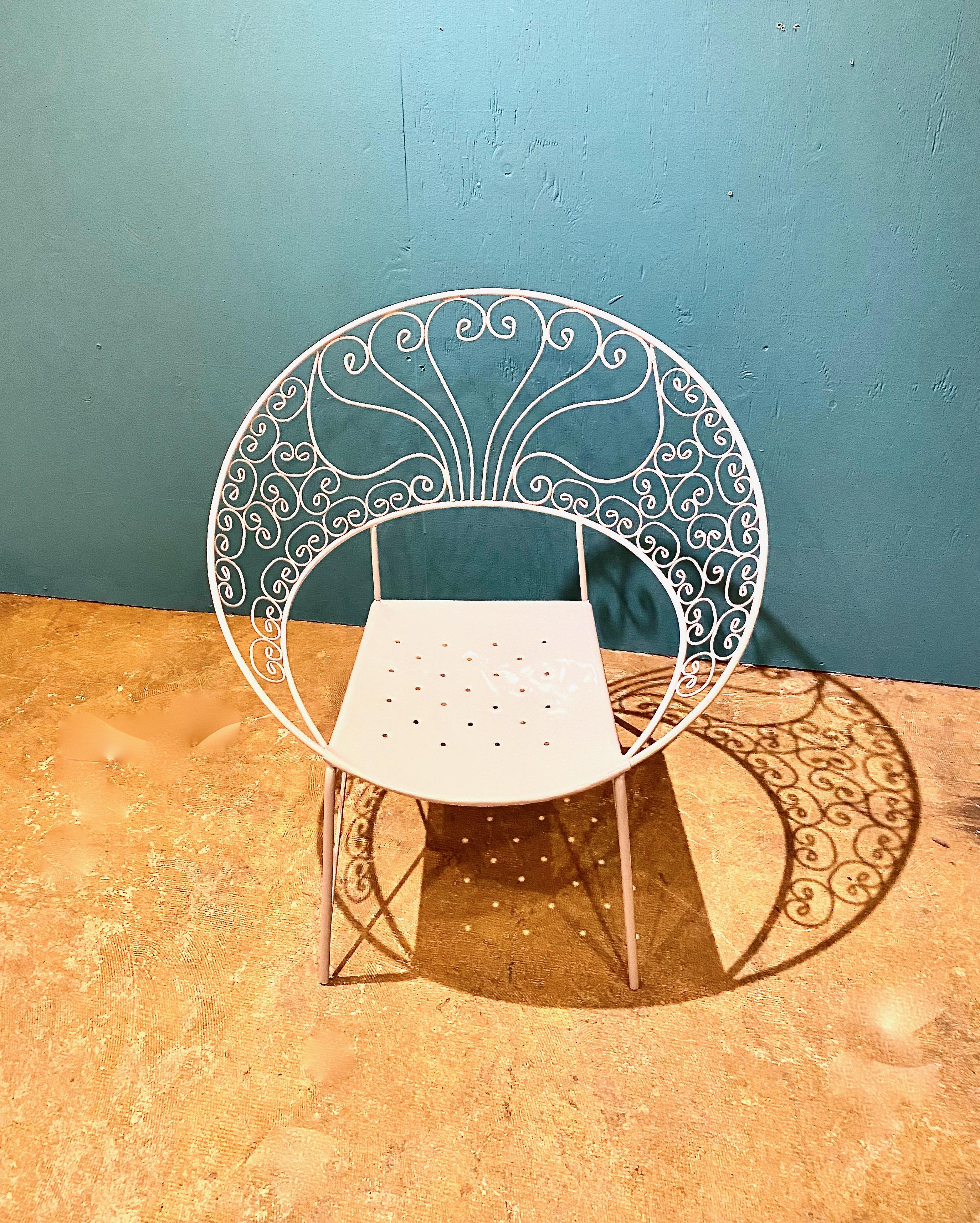 This is a striking suite of 4 chairs with a cocktail table en-suite that date to c. 1950s-1960s. The suite features clam shell shaped chairs decorated in scrolling wrought iron. The chairs and table are all in stable, very good condition and have