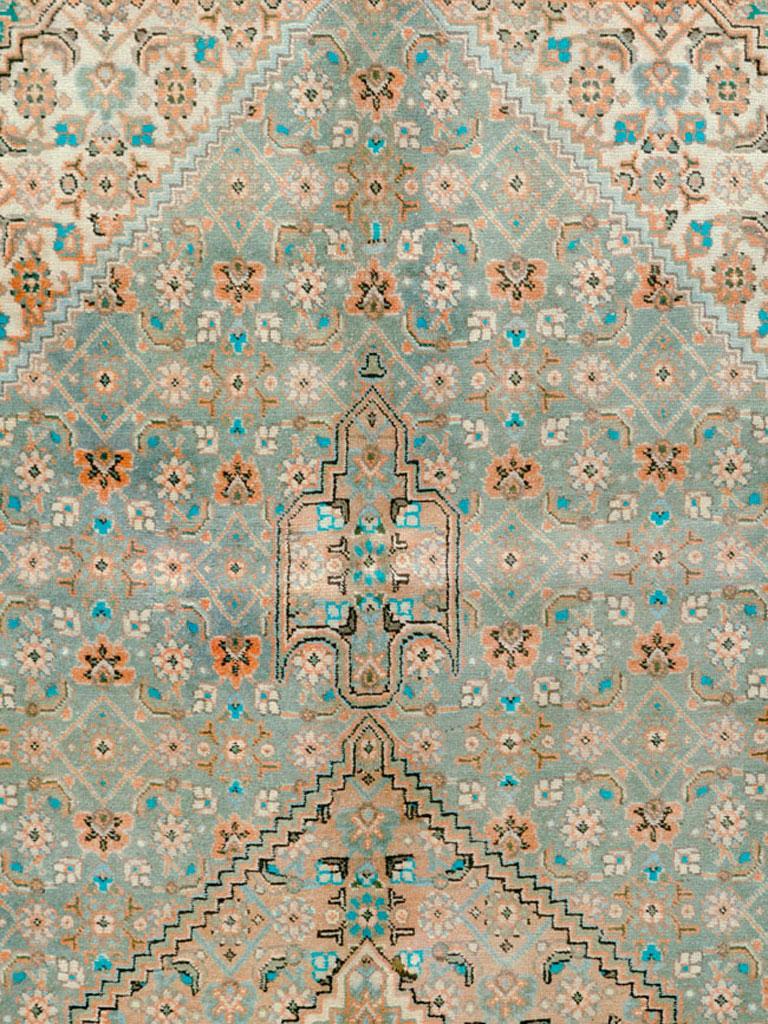 Ein alter persischer Täbriz-Teppich aus der Mitte des 20. Jahrhunderts. Schichten über Schichten des identisch skalierten Herati-Musters auf schiefergrünem, elfenbeinfarbenem und türkisfarbenem Grund füllen das hexagonale Unterfeld, das Feld, das